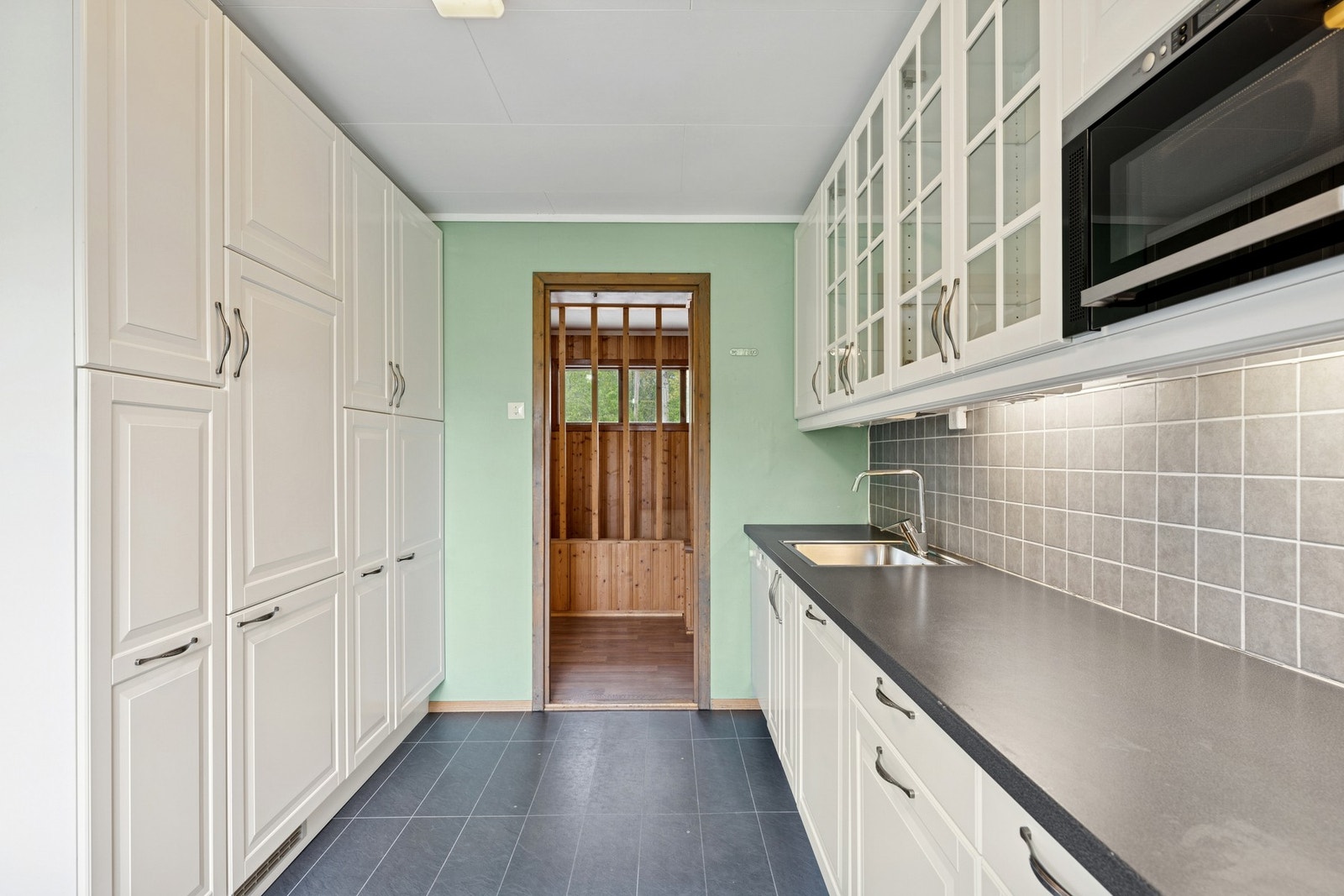 Kjøkkeninnredning fra IKEA med lys og tidløs stil, godt med skapplass og flislagt benkeflate. Galleribilde