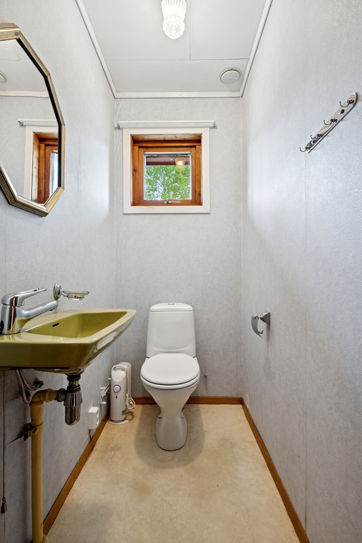 Separat toalettrom med servant og naturlig lys fra vindu. Galleribilde