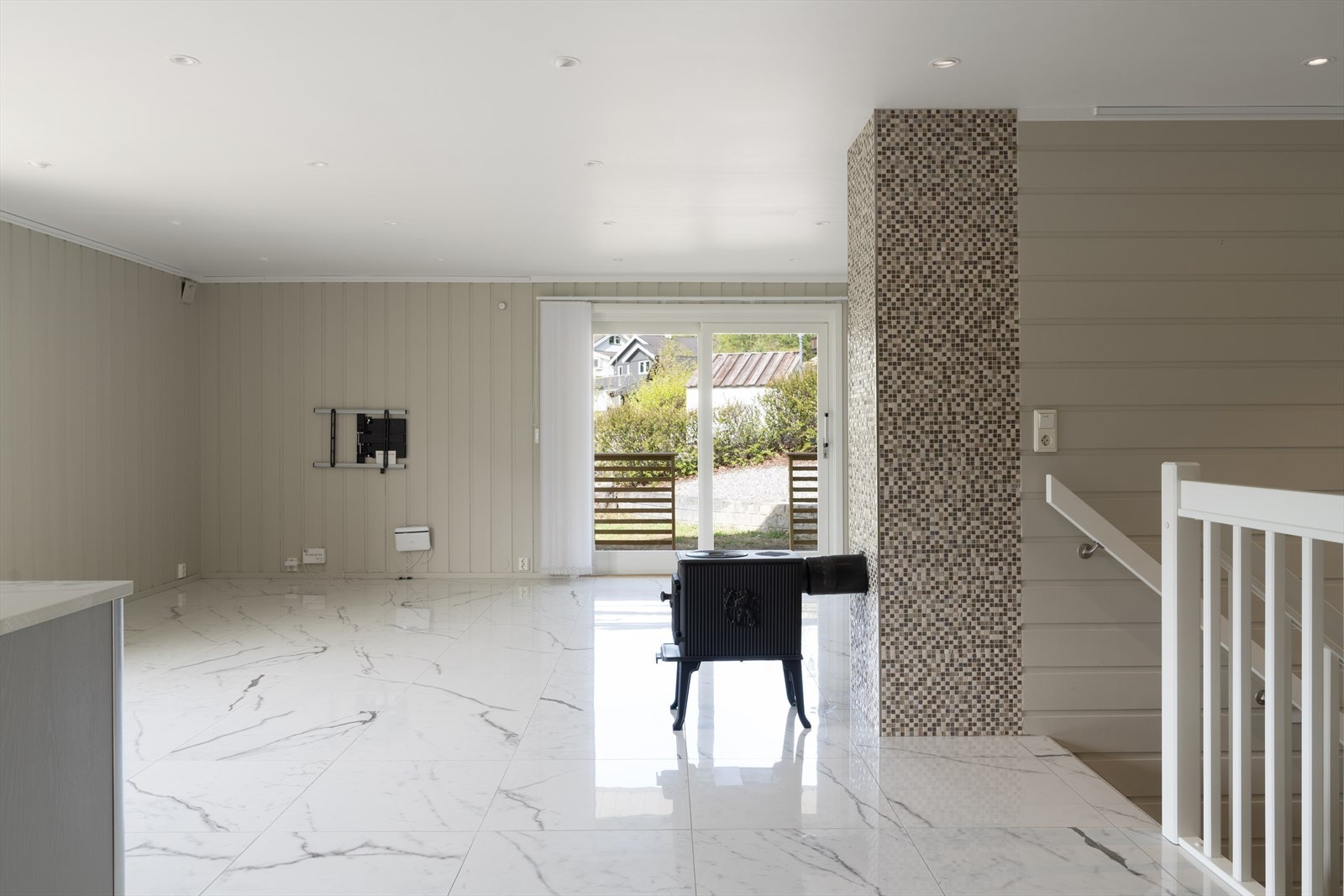 Lys og romslig stue med moderne detaljer, store vinduer som slipper inn naturlig lys og elegant flislagt gulv. Galleribilde