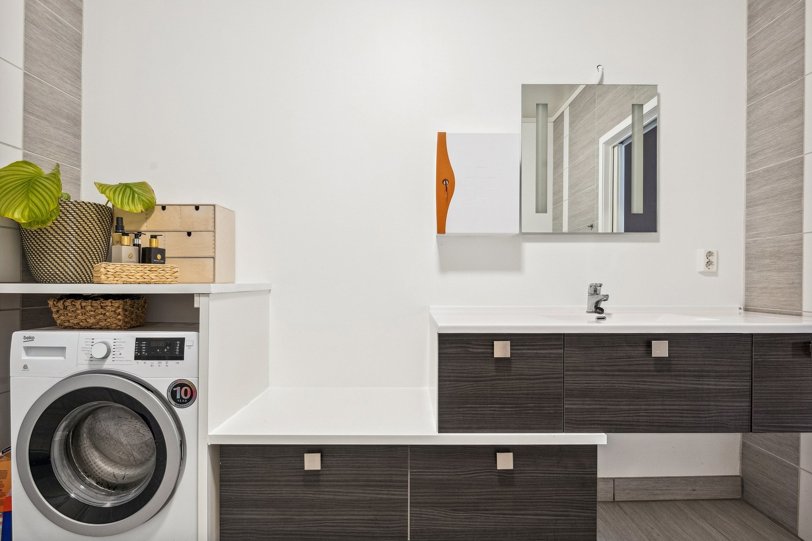 Gulvet er flislagt med elektriske varmekabler. Utstyrt med innredning som inkluderer en nedfelt servant og speil med lys. Veggmontert toalett, dusjvegger i et hjørnet. Galleribilde