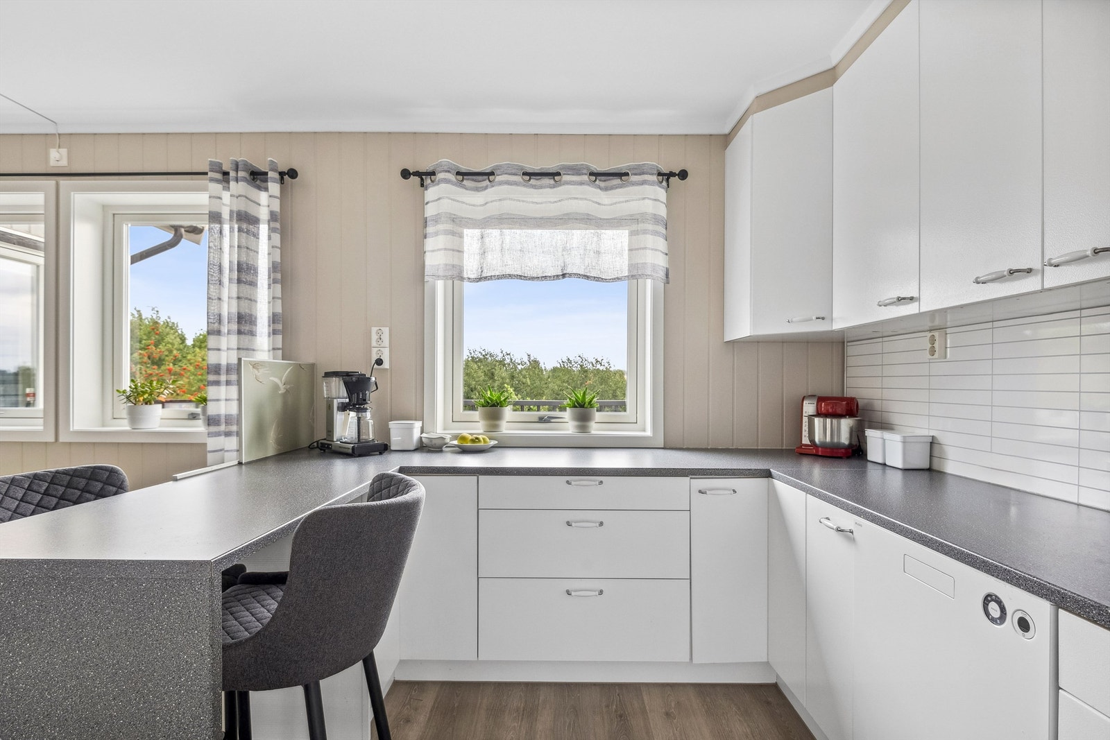 Dette romslige og innholdsrike kjøkkenet har en solid og moderne innredning med takhøye skap, samt rikelig med lagringsplass. Galleribilde