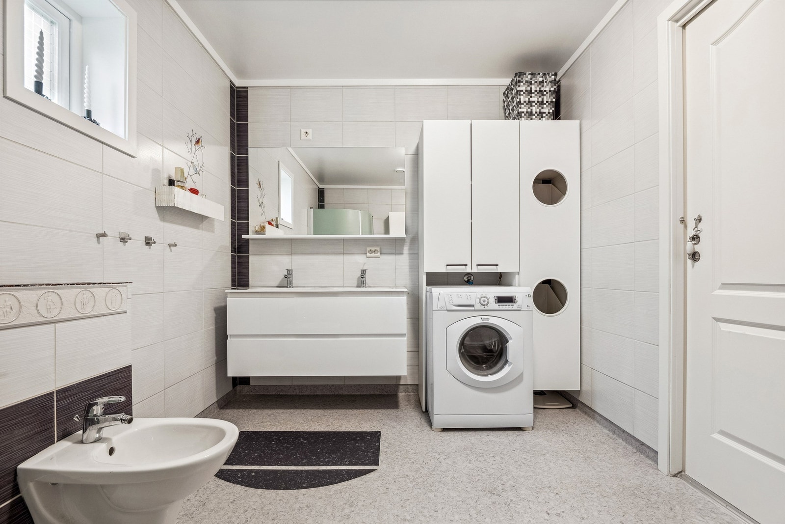 Badet er fra 2013 og har vegger dekket med fliser. Taket er malt og gulvet er dekket med vinylbelegg utstyrt med elektriske varmekabler. Praktisk innredning med to nedfelte servanter. Galleribilde