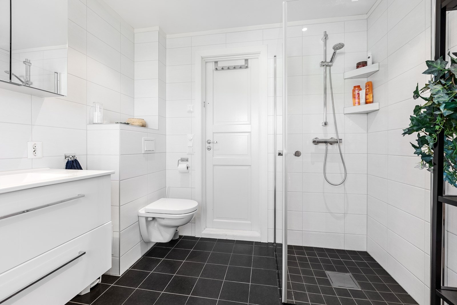 Dusj med glassdører og vegghengt WC. Galleribilde