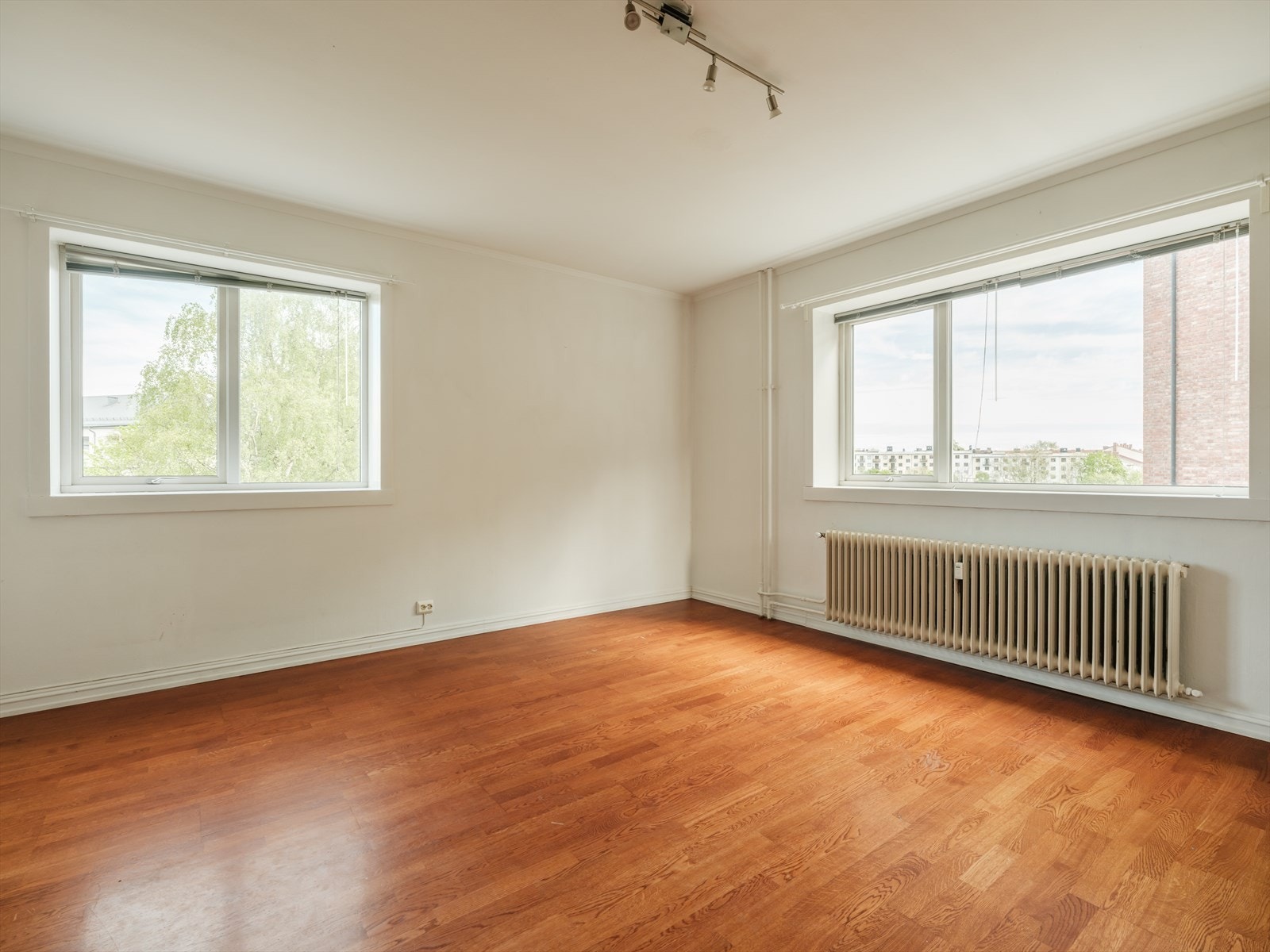 Lys hjørnestue med vindusflater på hele tre sider. Galleribilde