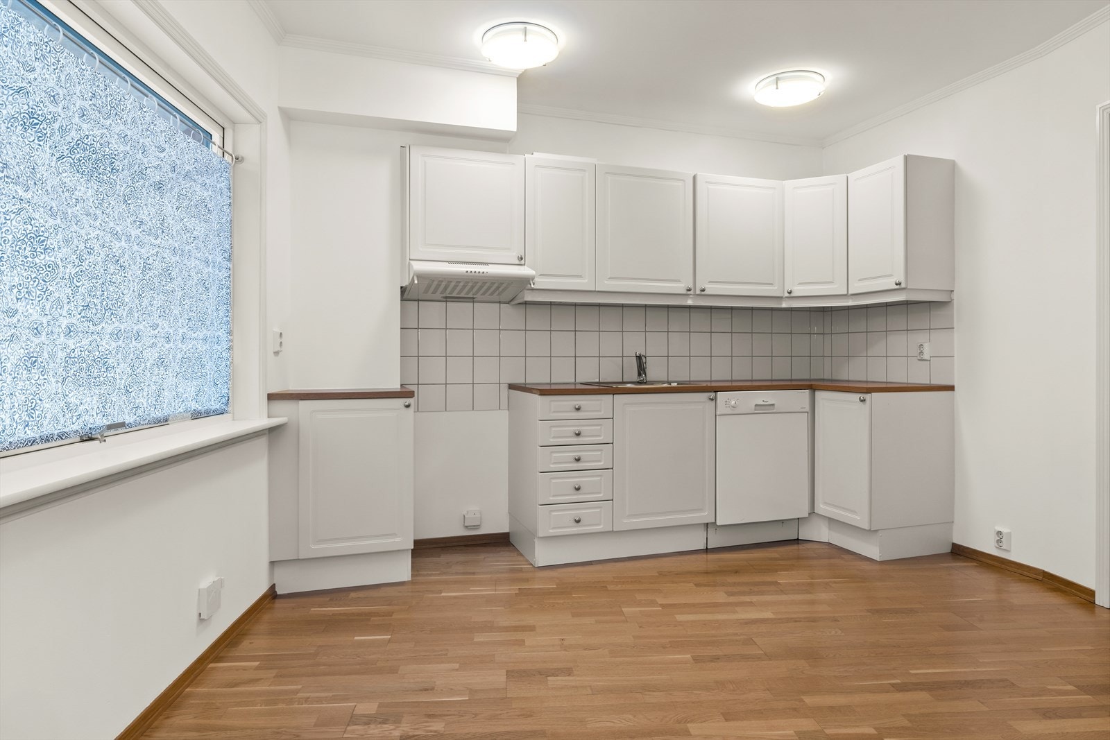 Romslig, separat kjøkken med lyse overflater. Innredningen er fra byggeåret 2004, med profilerte fronter og laminerte benkeplater. Over avsatt plass til komfyr, ble det byttet ventilator i 2024. Avtrekk fra ventilatoren er felles for flere leiligheter Galleribilde