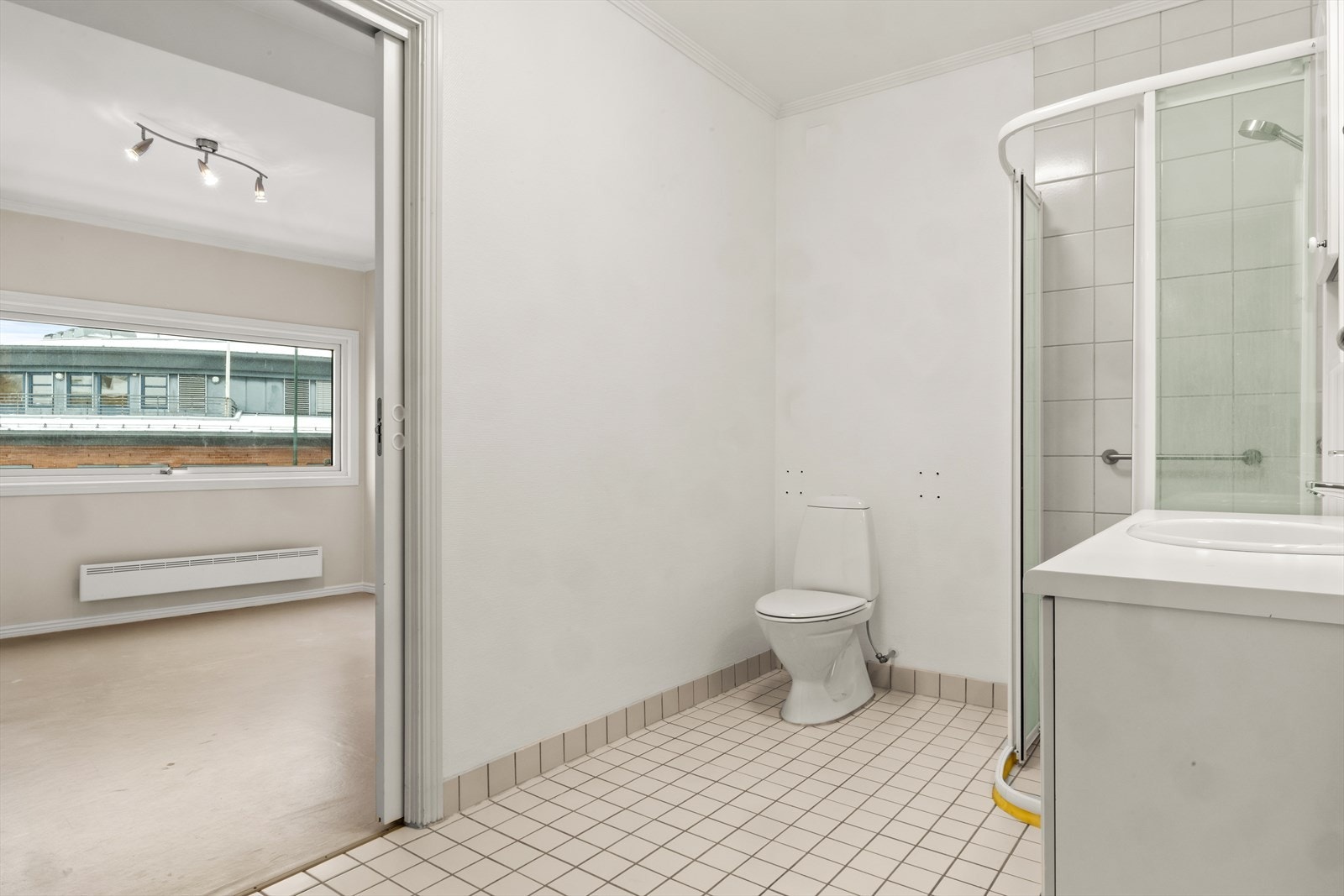 Baderommet har en standard fra byggeåret, med fliser på gulvet og på vegg i dusjsonen, øvrige veggoverflater har malt glassfiberstrie. Det er varmekabel i gulvet og dusjhjørne med skyvedører. Det finnes HC-håndtak som følger med til toalettet. Galleribilde