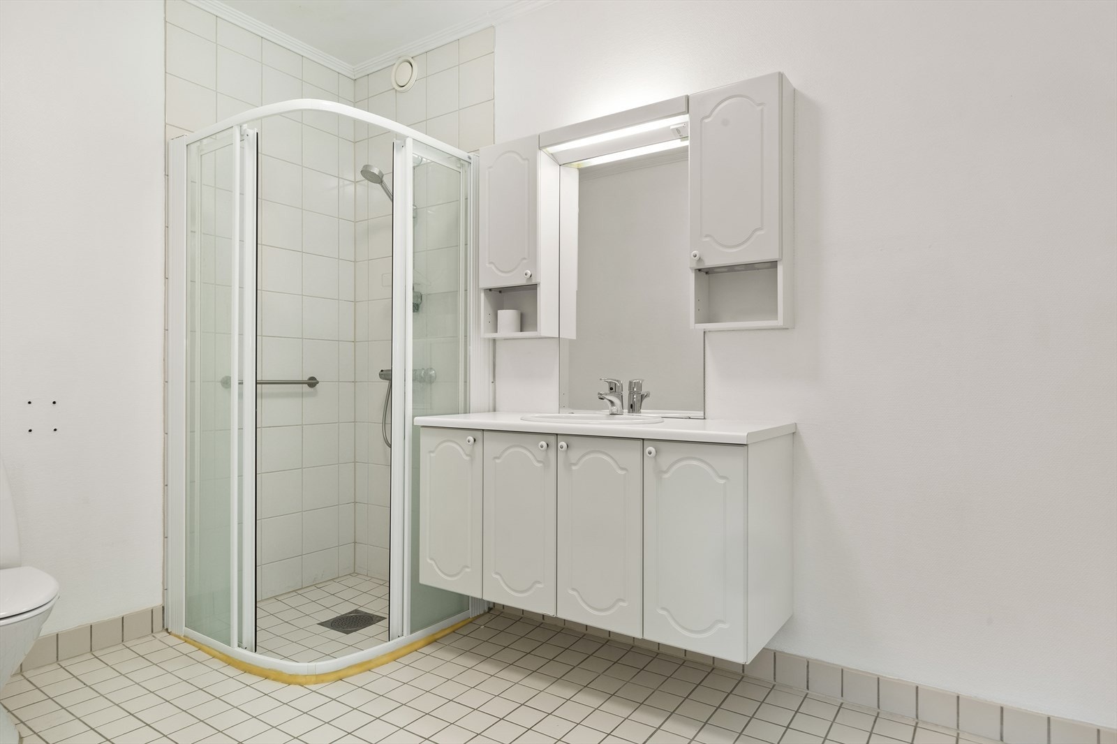 I tillegg er det en klassisk baderomsinnredning med nedfelt servant og speil mellom overskap Galleribilde