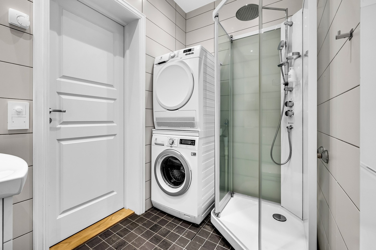 Badet er utstyrt med vegghengt servantskap, dusjkabinett, toalett og opplegg for vaskemaskin og tørketrommel. Galleribilde