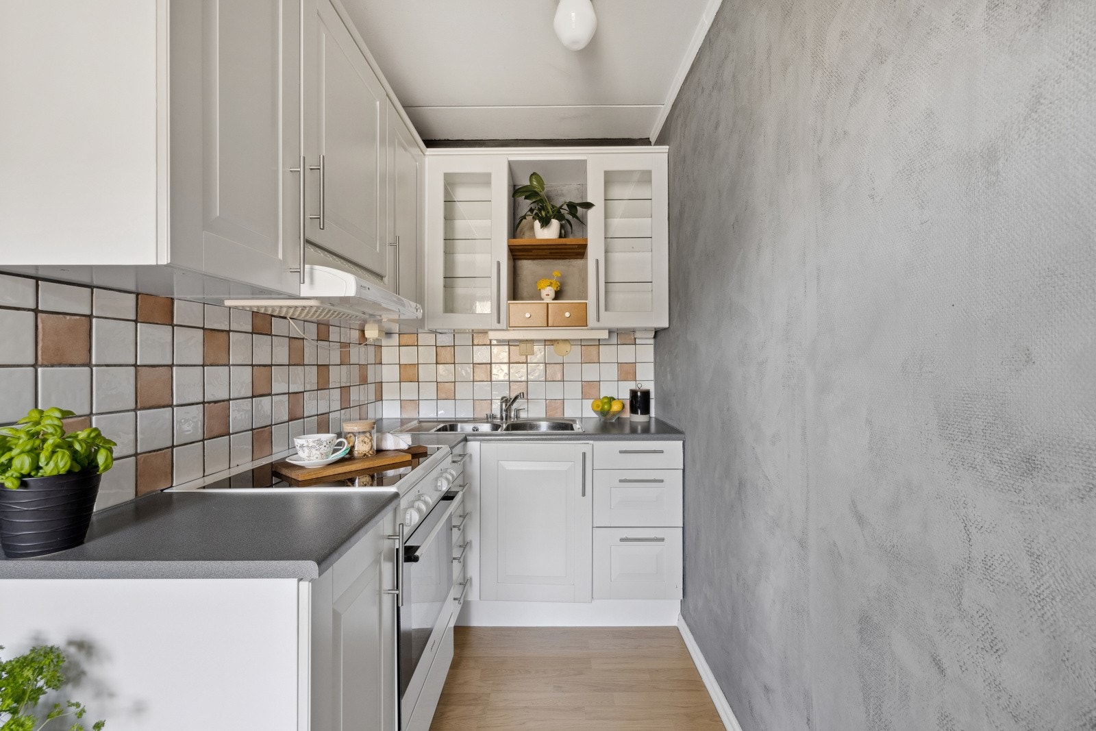 Lyst kjøkken med god skap- og benkeplass. Kjøkkeninnredning med hvite profilerte fronter. Galleribilde