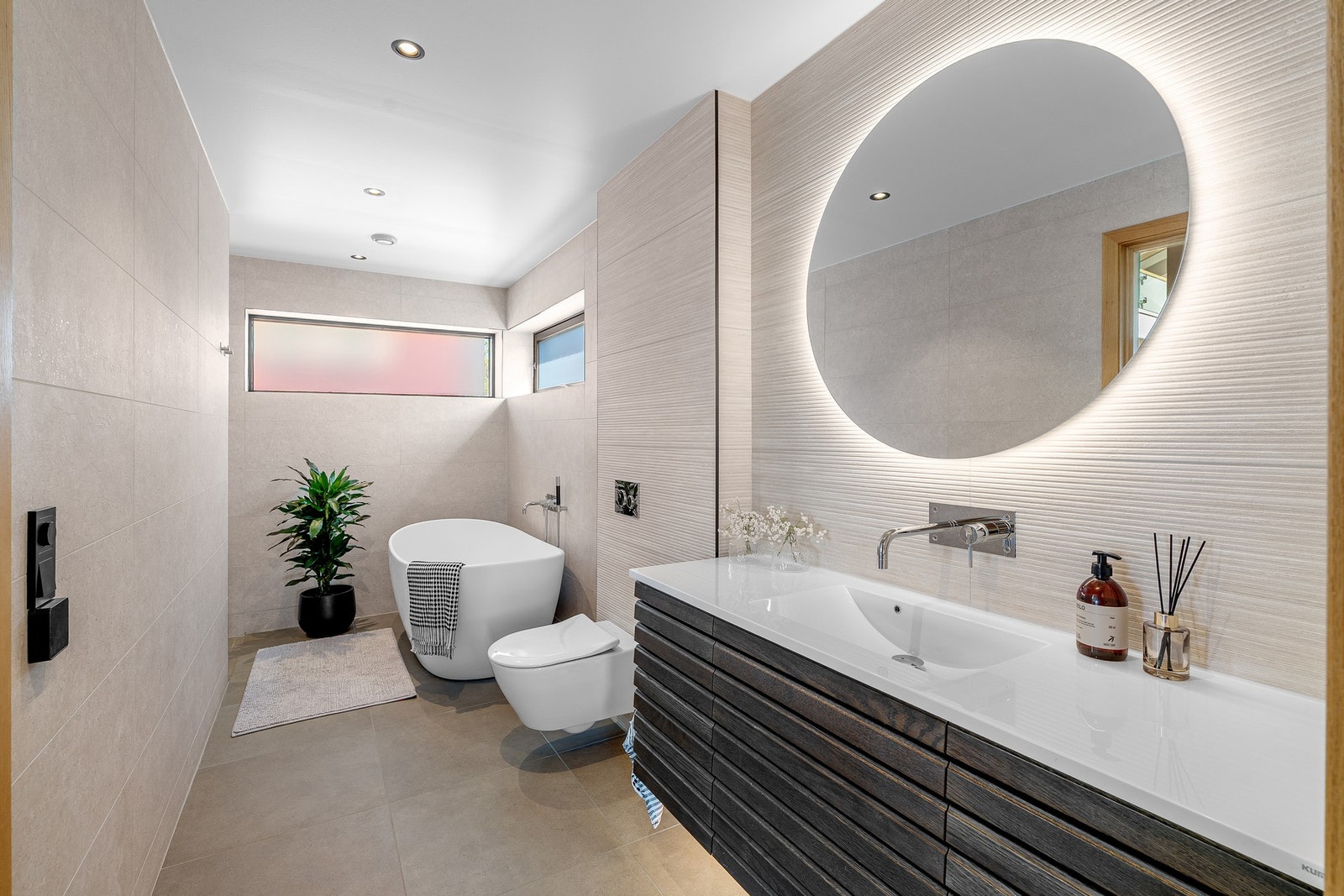 Stort bad med moderne design, nydelig belysning og praktiske løsninger. Galleribilde