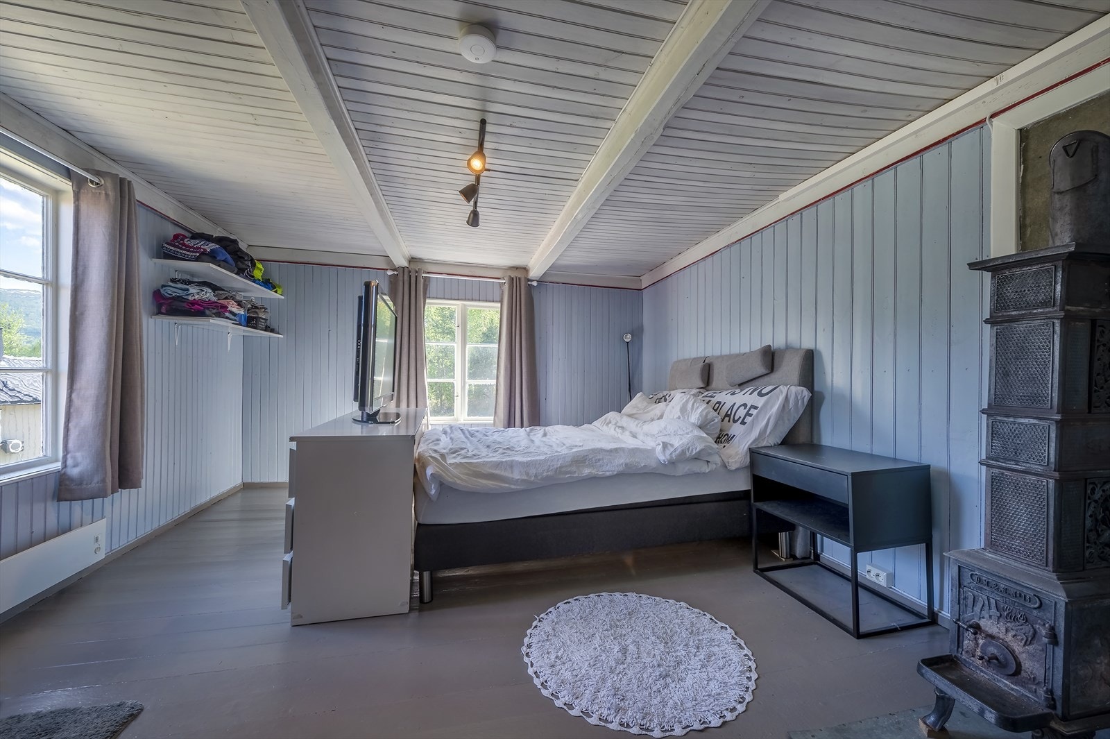 Det største soverommet ligger i søndre hjørne og er hele 15,5 m² - Her finner en også en flott etasjeovn fra O. Mustad & Søn Galleribilde