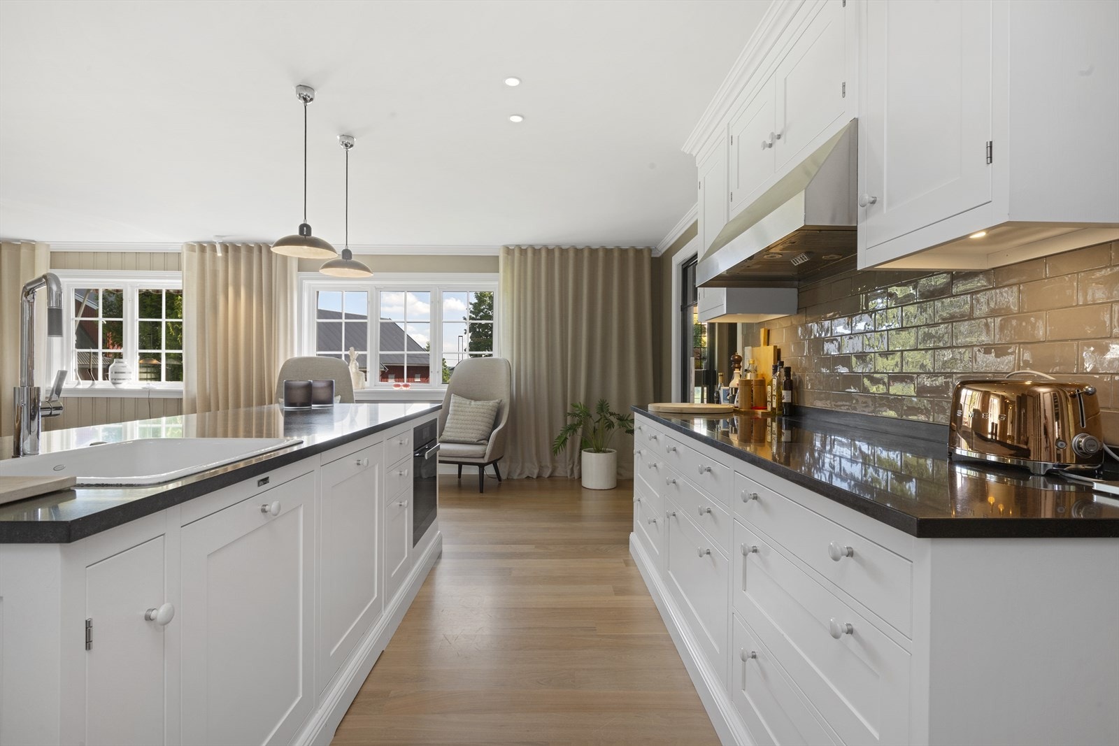 Et stort kjøkken og allrom med ekslusiv innredning, integrerte hvitevarer og gode arbeidsflater. Galleribilde