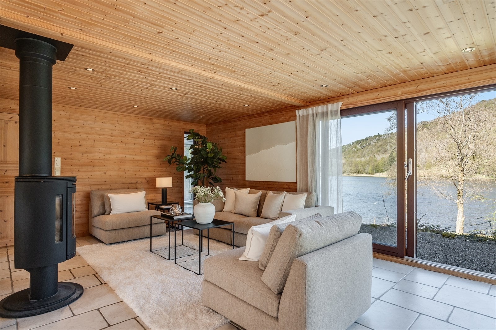Stuen har store vinduer og to skyvedører med direkte tilgang til hagen. Galleribilde