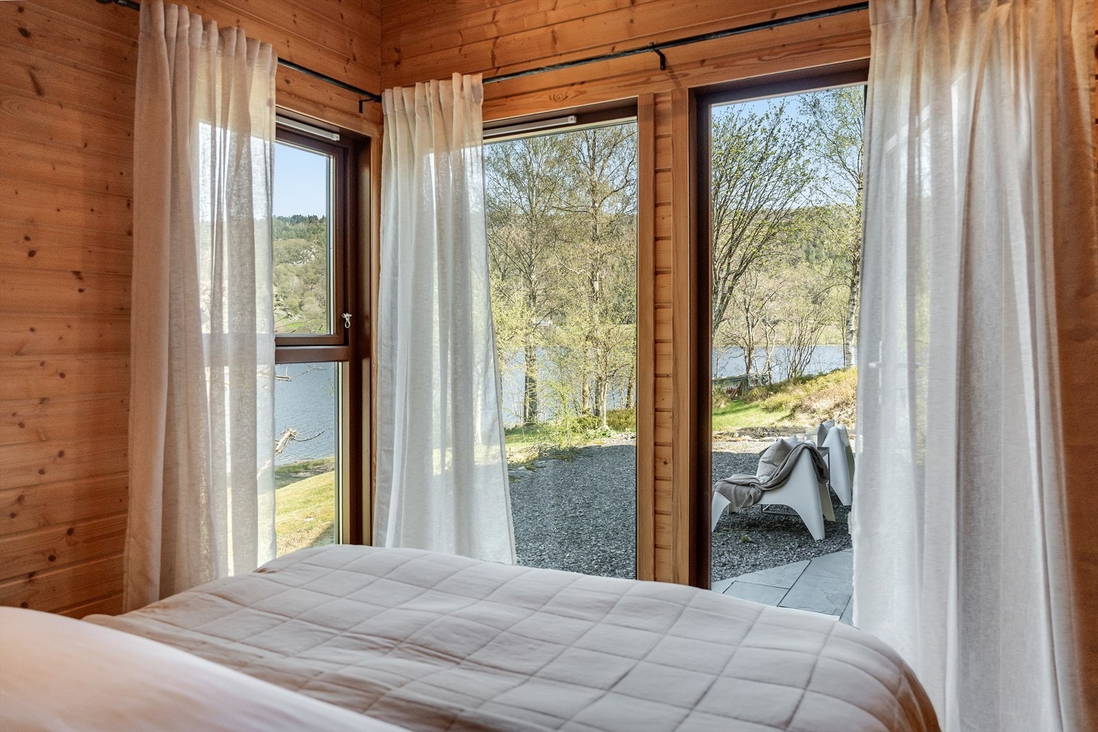Et romslig soverom med god garderobeløsning og egen terrassedør som leder rett ut til hagen. Rommet har parkett på gulvet og panel på vegger og himling, komplett med downlights. Galleribilde