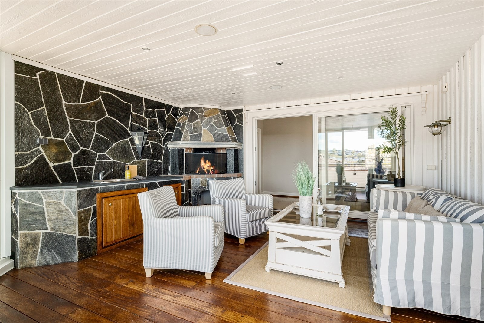 Fra hovedstuen er det adkomst til vinterhagen, som er flott innredet med skiferkledd tekjøkken og gruepeis. Galleribilde