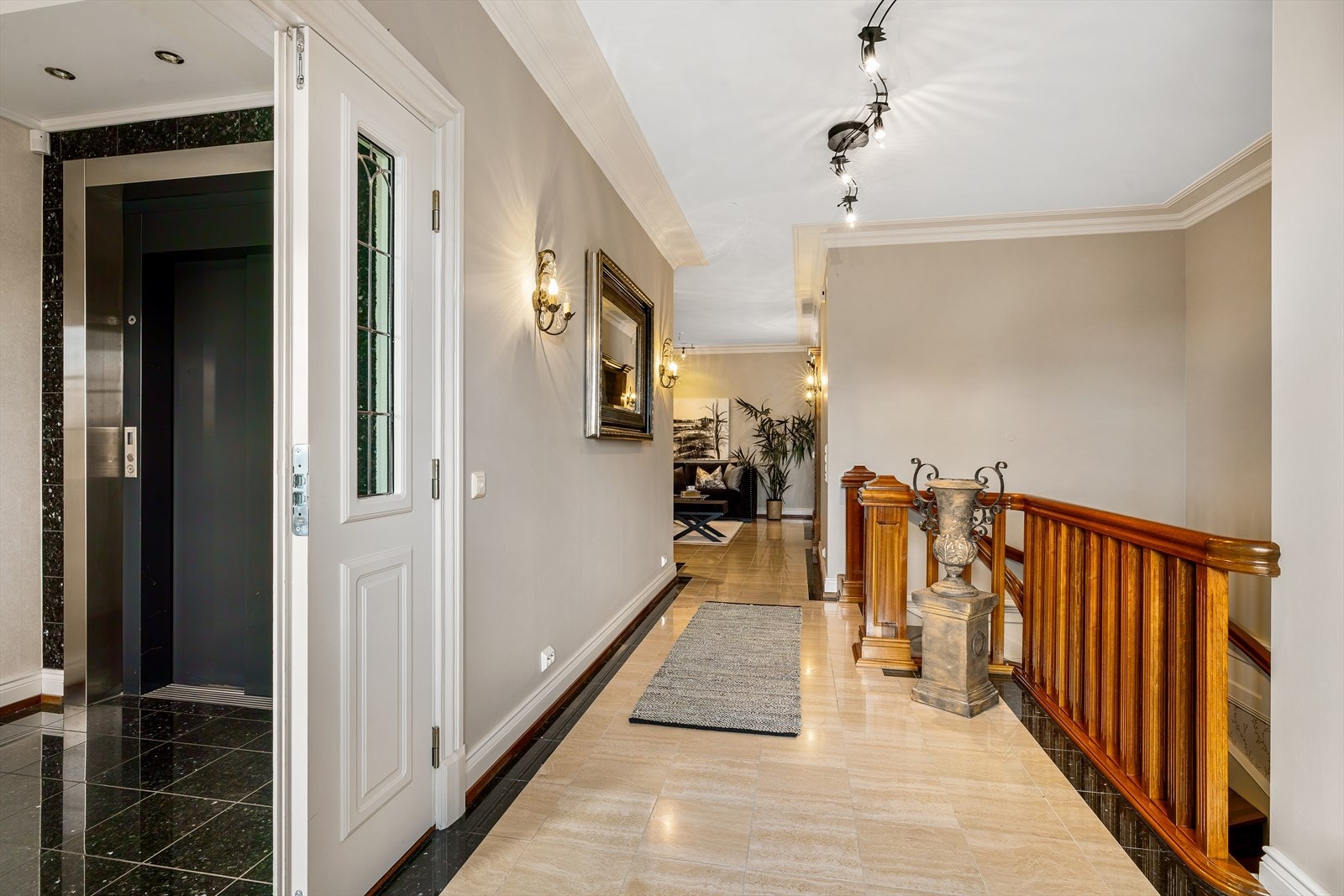 Den elegante trappen i heltre fører ned til leilighetens andre entré som ligger i tredje etasje. Galleribilde