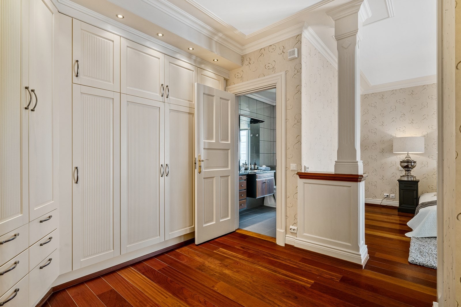 Garderoben fremstår skreddersydd med lyse, plassbygde skap, skuffer og downlights i gesims. Galleribilde