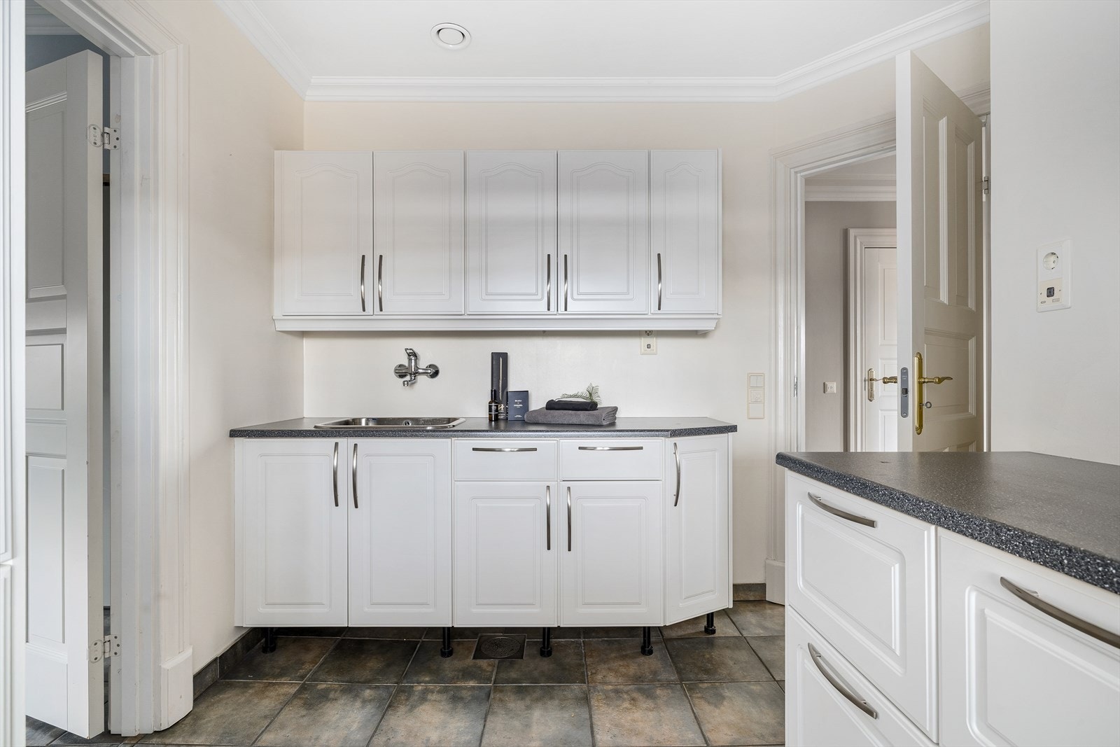 Vaskerommet er lyst og pent med flislagt gulv og god skapplass i en pen, hvit innredning. Galleribilde