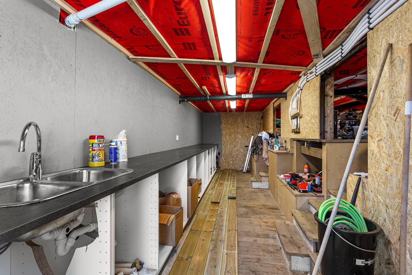 Romslig hobbyrom med skapinnredning som har nedfelt utslagsvask og god plass på arbeidsbenk Galleribilde