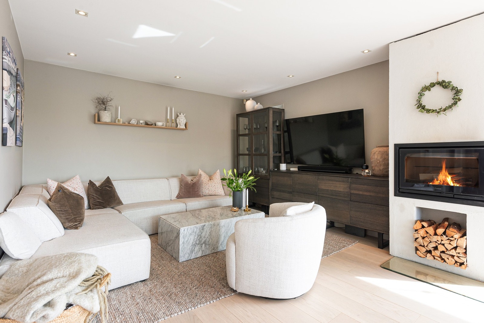 Downlights gir jevn og god belysning i rommet, mens peisen skaper en lun stemning - perfekt for avslapning i sofakroken Galleribilde