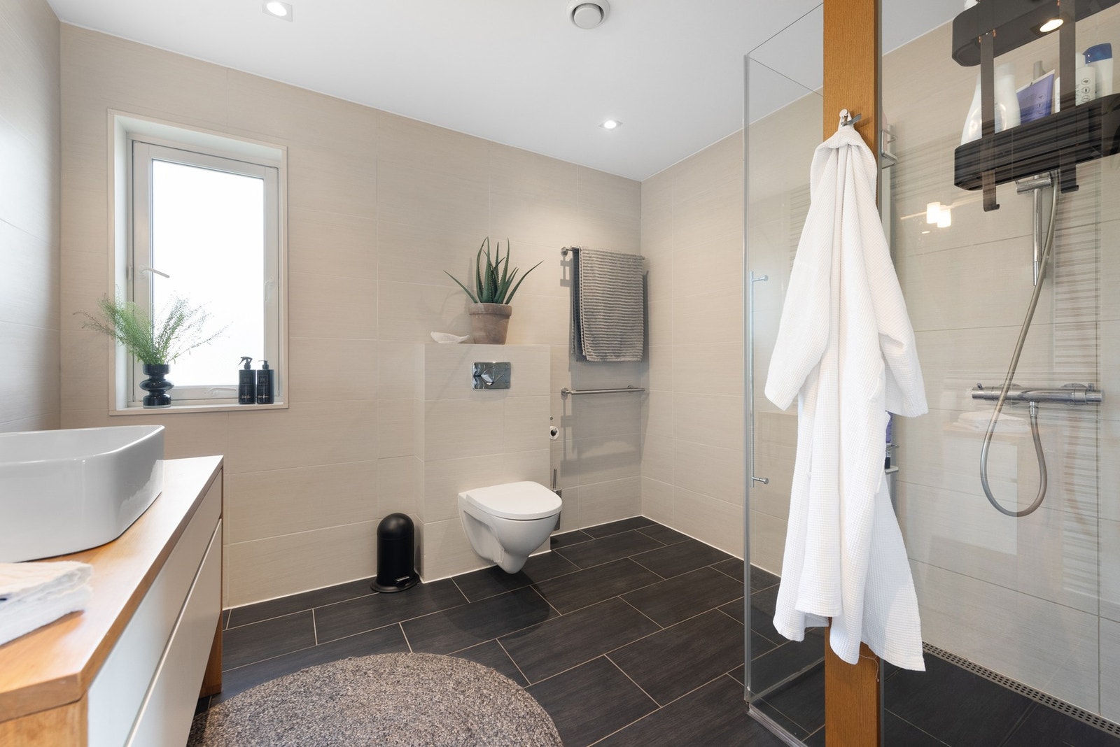 Badet i etasjen romslig og elent innredet med dusjhjørne, servant i innredning med skuffer og vegghengt toalett Galleribilde