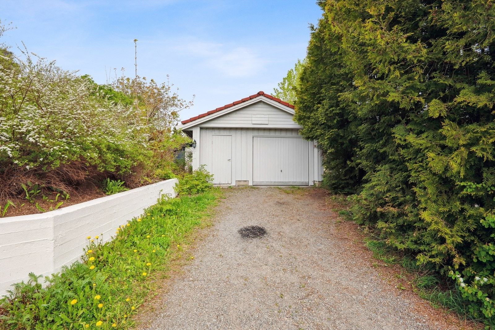 Det er en garasjeplass i en frittstående garasje på gårdsplassen. Videre er det plass til å parkere en bil på baksiden av garasjen. Galleribilde