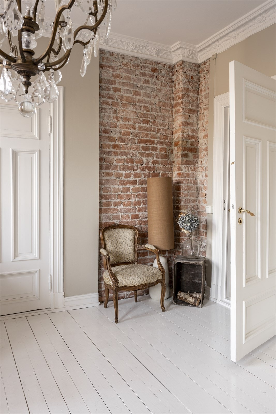 Gulvene i leiligheten er av malte gulvbord - Legg merke til teglsteinsveggen som gir rommet både dybde og sjarm. Galleribilde