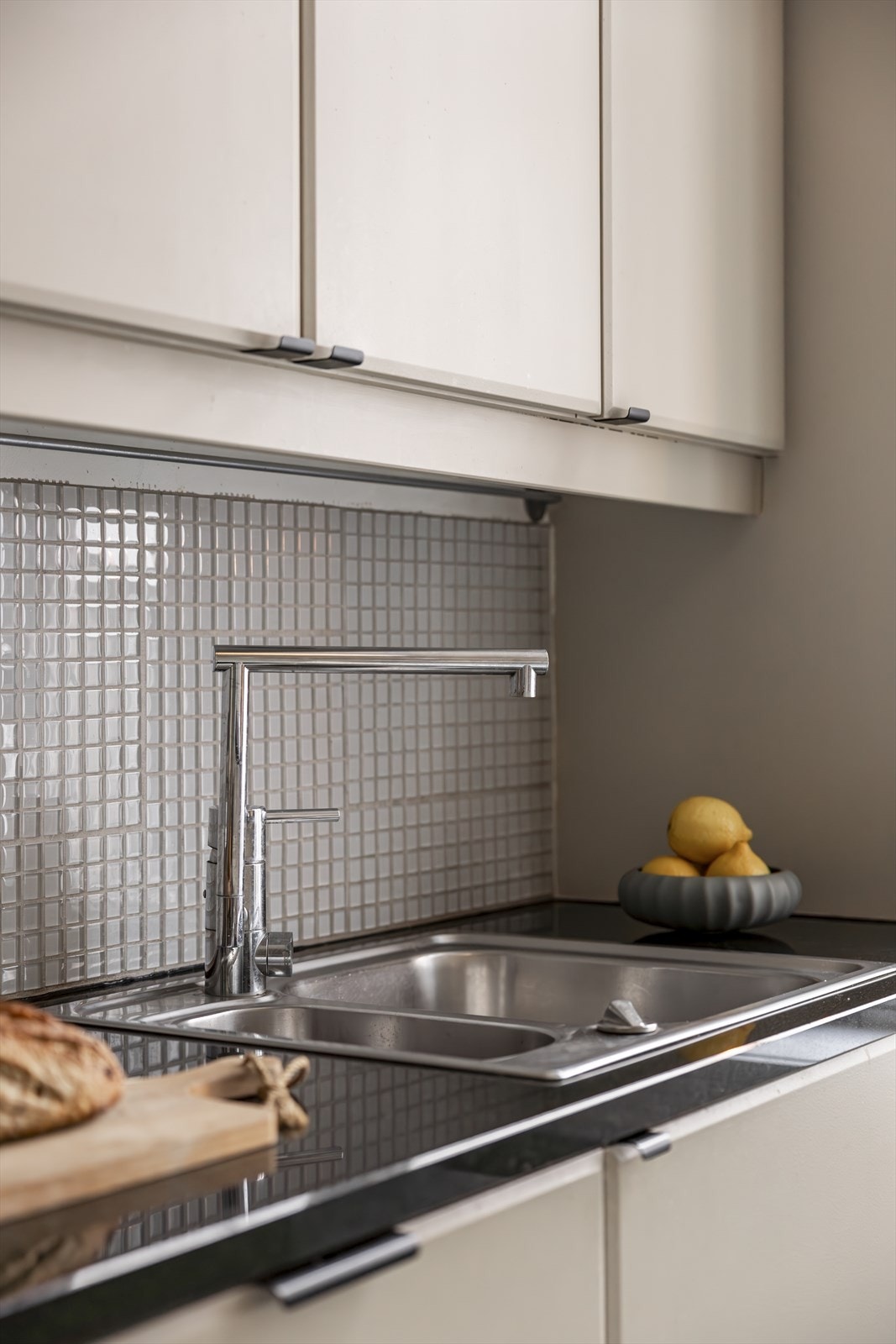 Lekker benkeplate i granitt og mosaikkfliser over benkeskap. Galleribilde