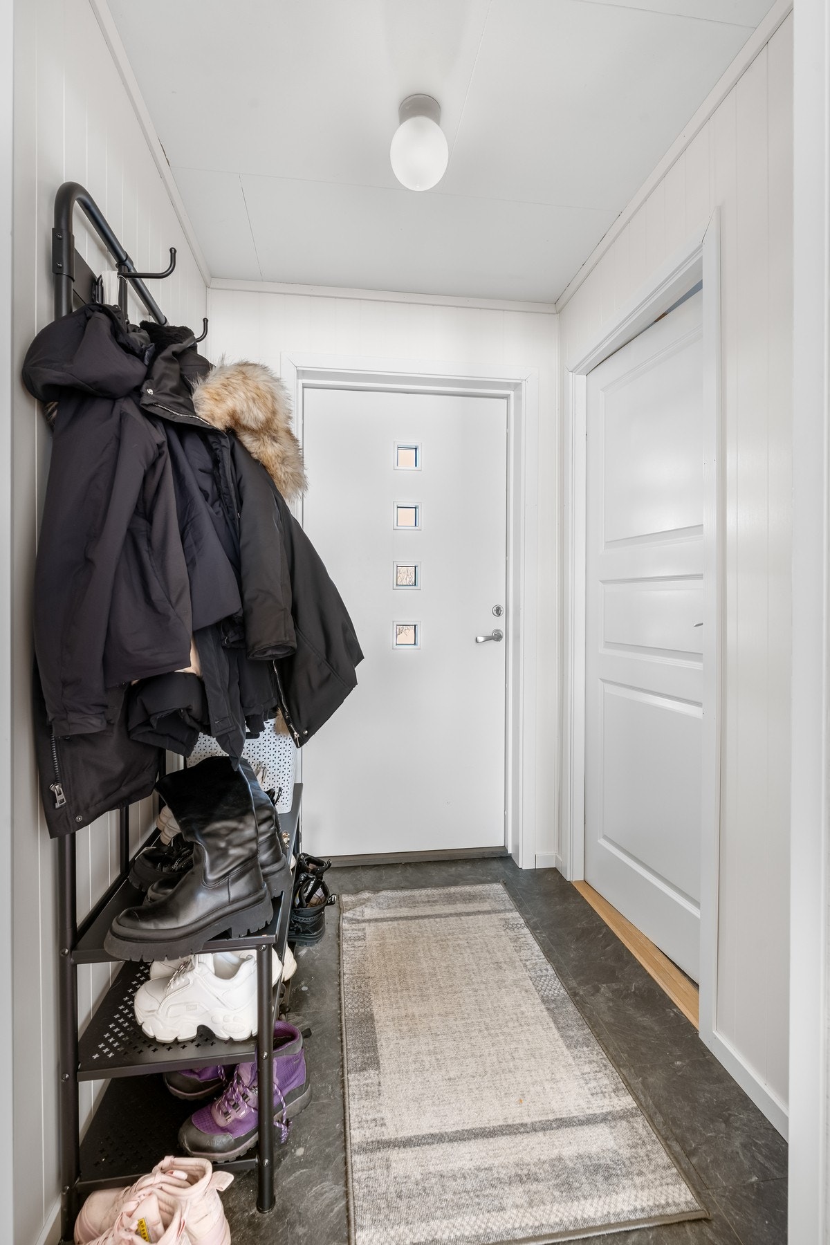 Vindfang leilighet - her er det plass for oppbevaring av klær og sko. Det er etablert bod i tilknytning til vindfanget Galleribilde