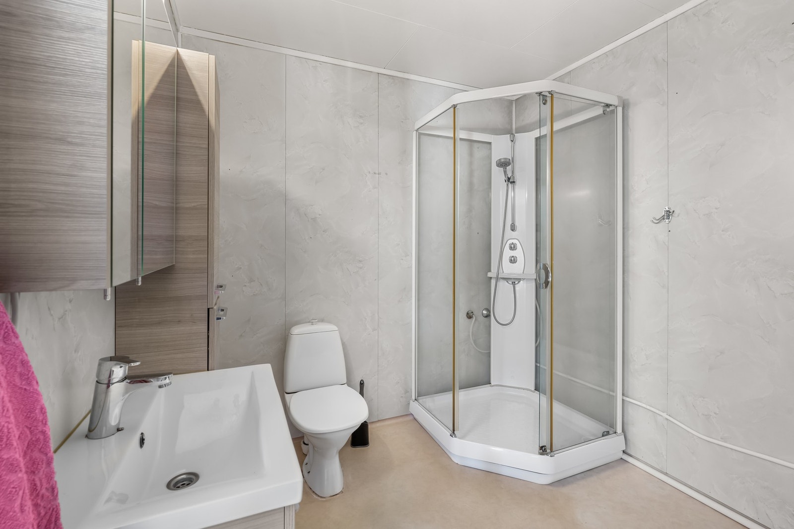 Badet er innredet med baderomsinnreding, toalett og dusjkabinett Galleribilde