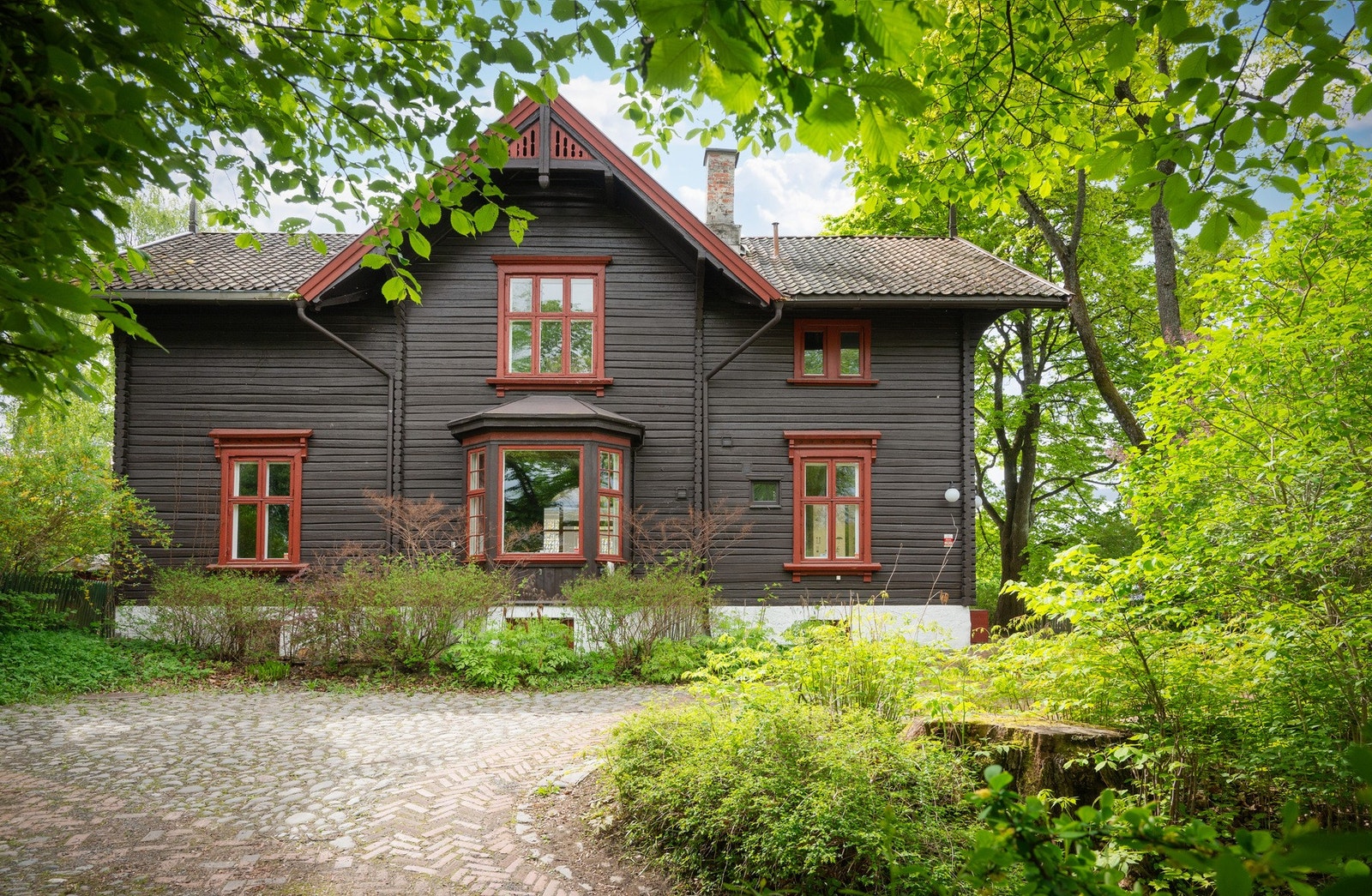 Det er brosteinsbelagt gårdsplass med plass parkering av biler. Galleribilde