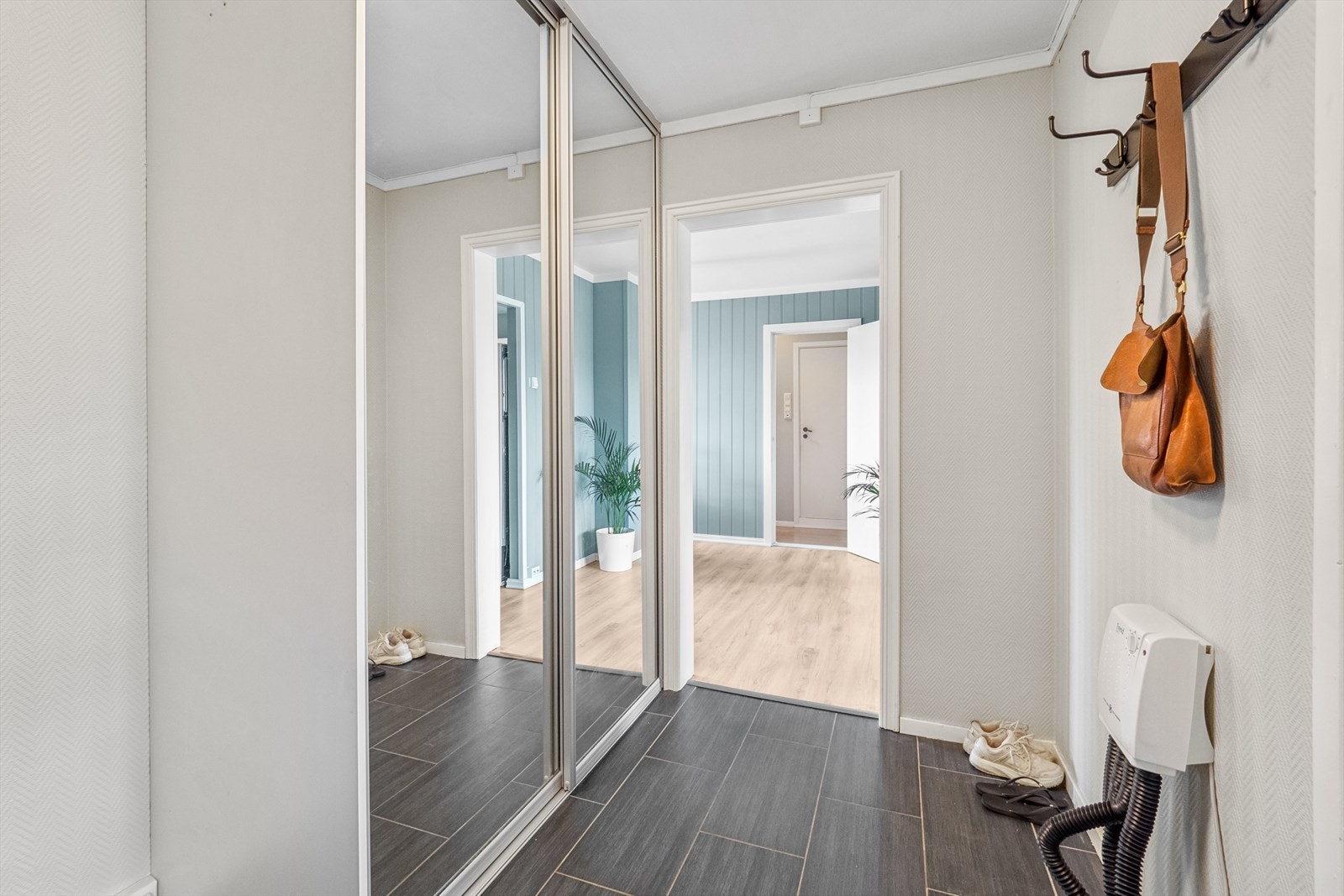 Yttertøyet kan oppbevares i en praktisk skyvedørsgarderobe med speilfronter. Galleribilde