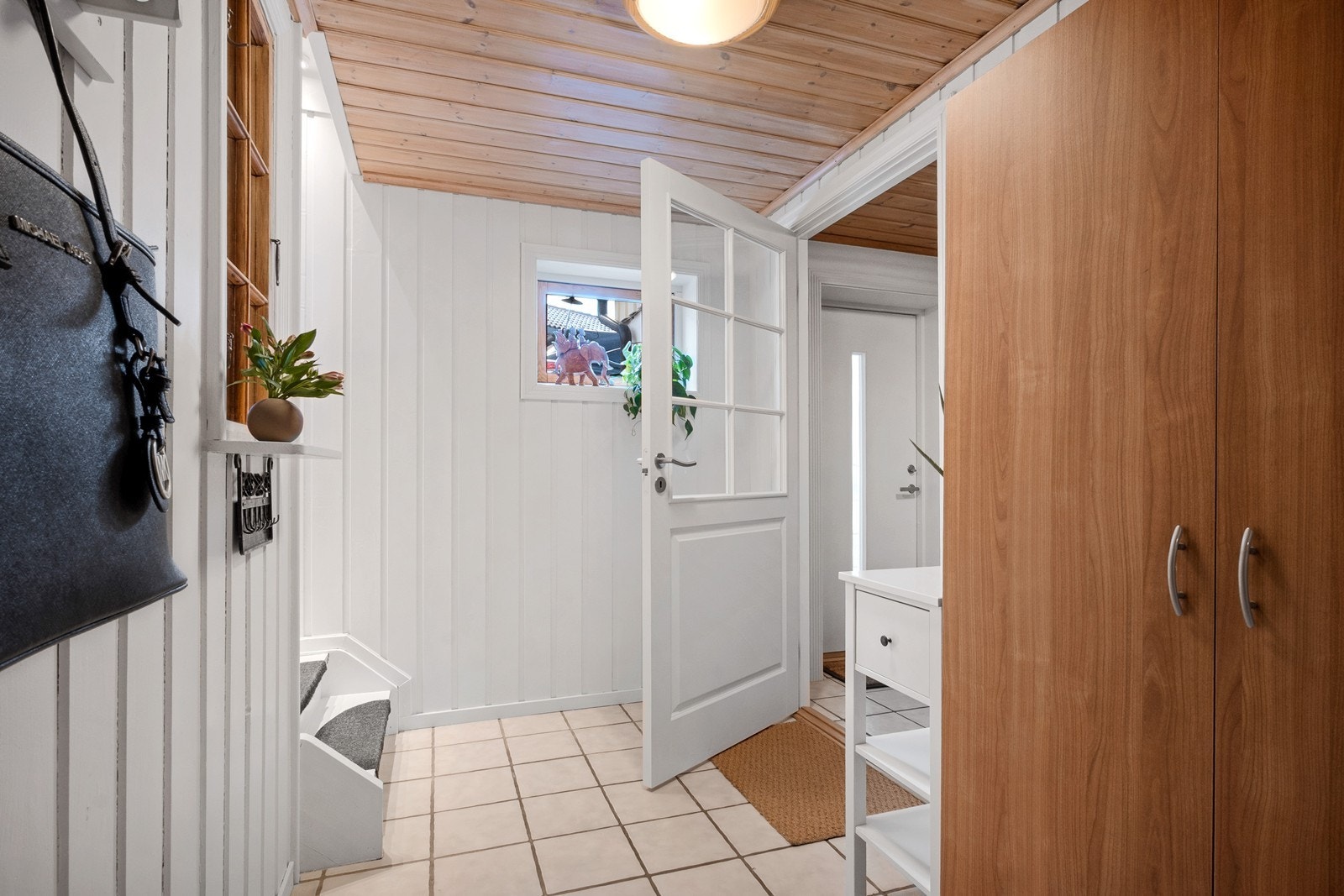 Videre kommer man inn i mellomgang og trapp opp til 1. etasje, innredet med garderobeskap, speilvindu og knagger. Galleribilde