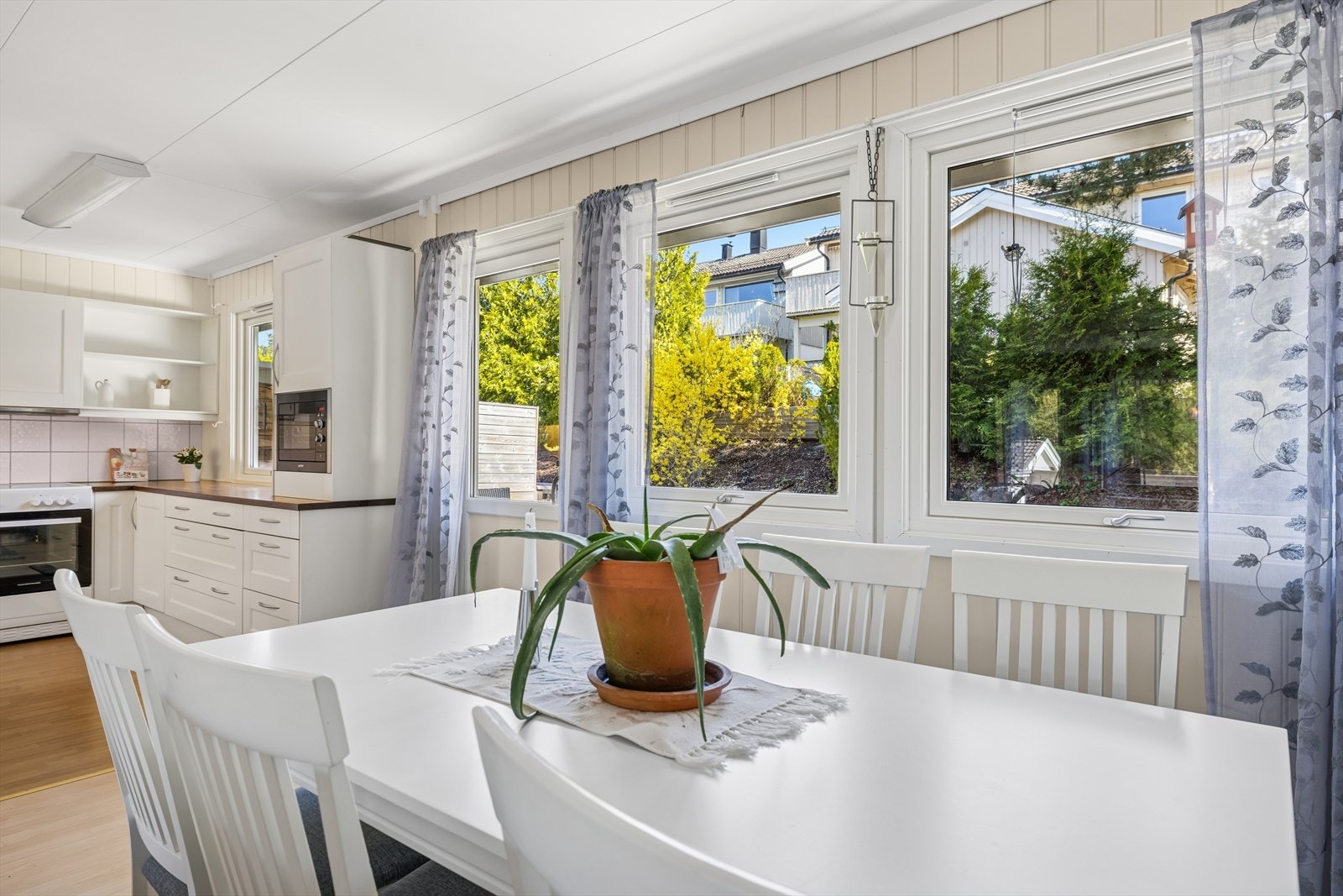 Romslig nyere kjøkken med plass til spisebord - sosial og praktisk løsning. Galleribilde