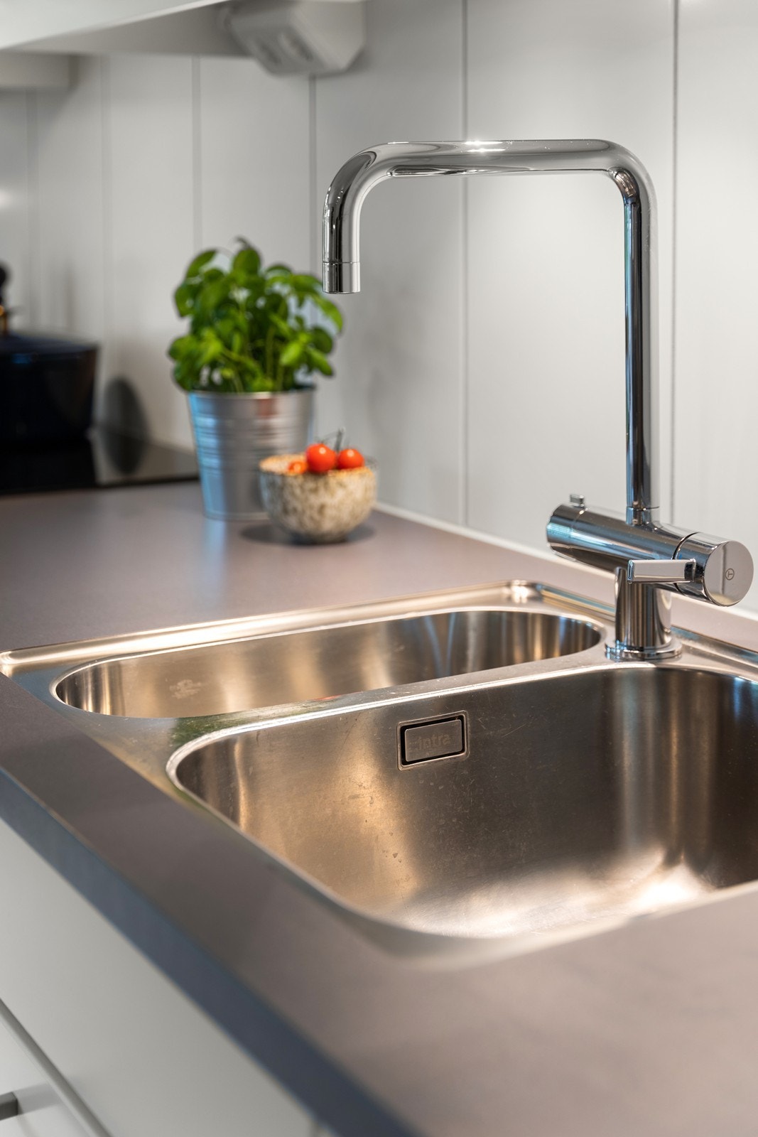 Det er benkeplate i laminat med nedfelt vask- og skyllekum. Galleribilde