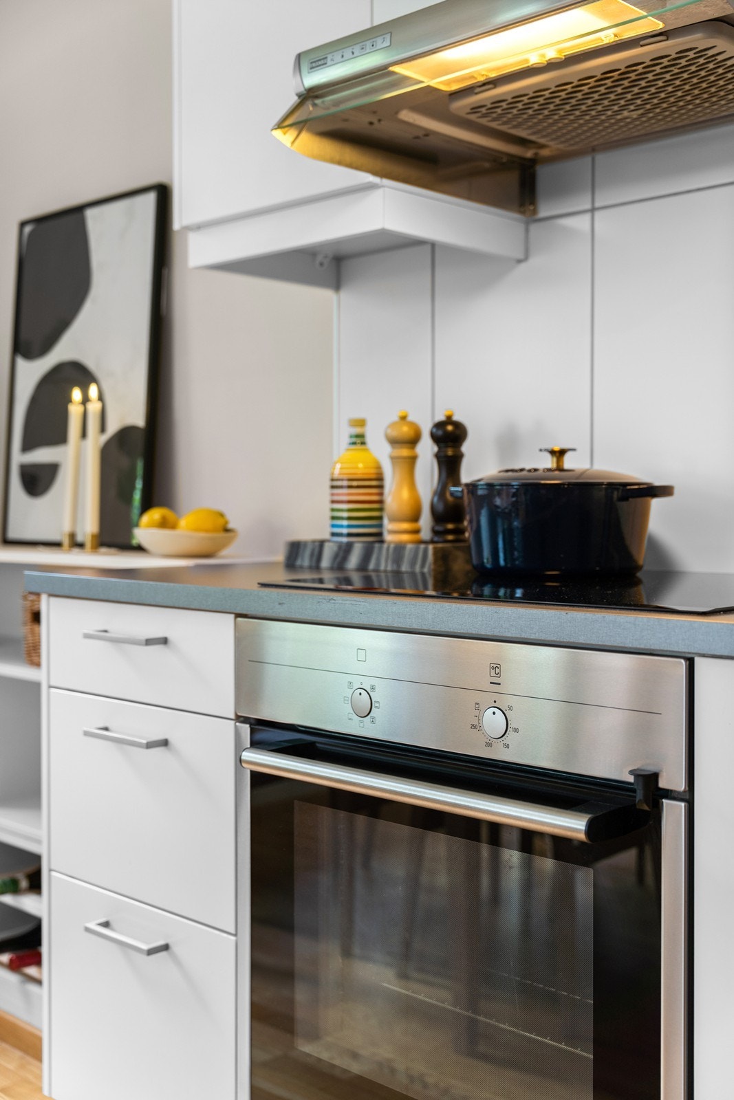 Kjøkkenet har store, fine hvite fliser mellom over- og underskap. Galleribilde