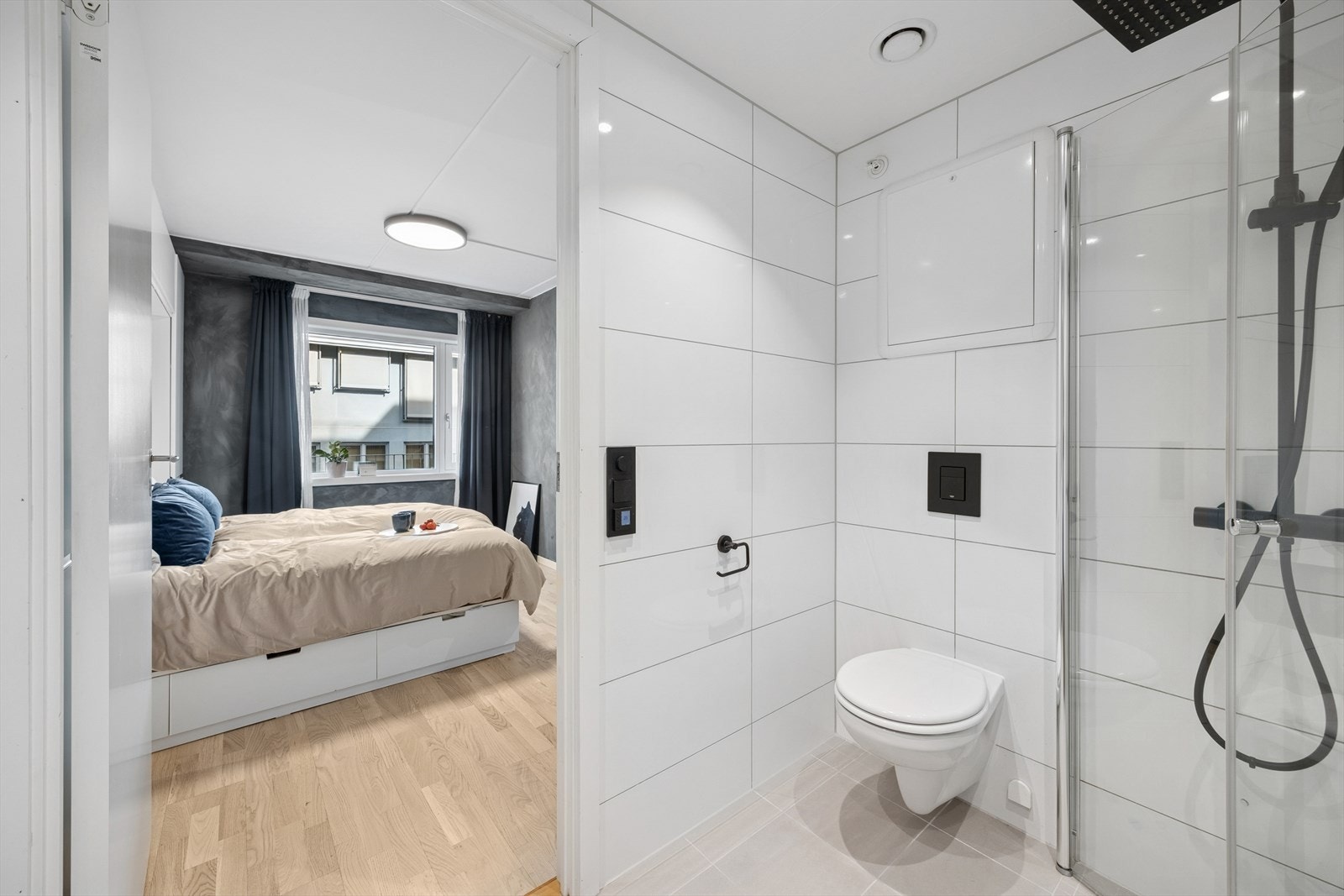 Dusjhjørnet har innfellbare glassdører og veggmontert dusjsett med både hånd- og regndusj. Galleribilde