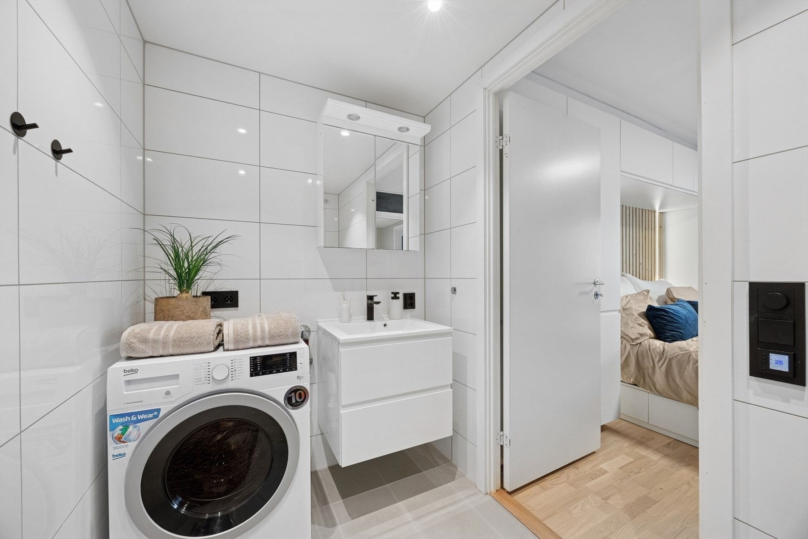 Baderomsinnredningen er pent utført med hvite fronter, romslige skuffer og heldekkende servant. Galleribilde