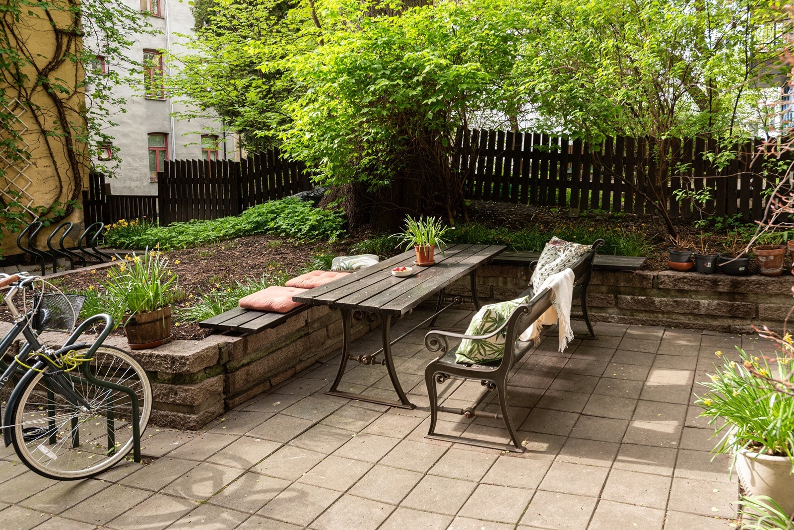 Pen og vedlikeholdt bakgård med felles sittegrupper. Galleribilde