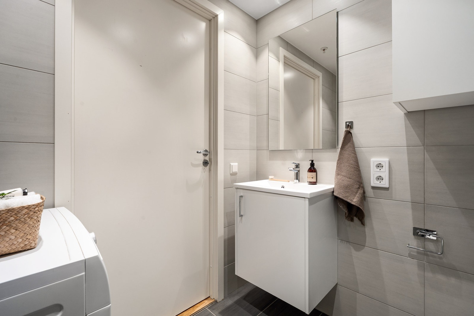 Stilfullt og moderne helfliset baderom med gulvvarme og malte flater i himling med downlights. Galleribilde