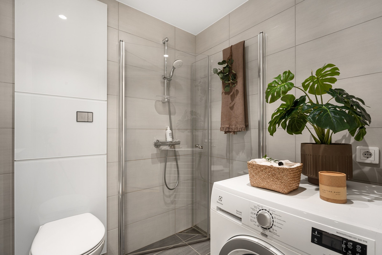 Badet er innredet med baderomsmøbler, dusjhjørne med dører og vegghengt toalett Galleribilde