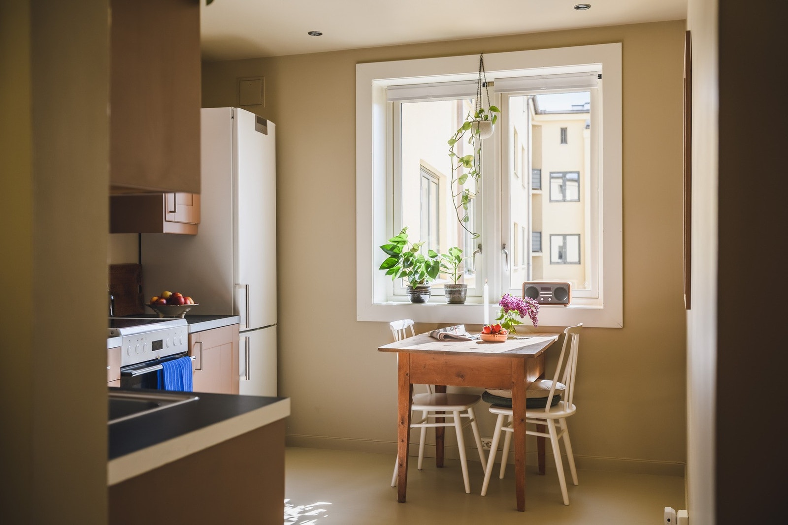 Plass til spisebord ved vinduet med utsikt mot hyggelig bakgård. Galleribilde