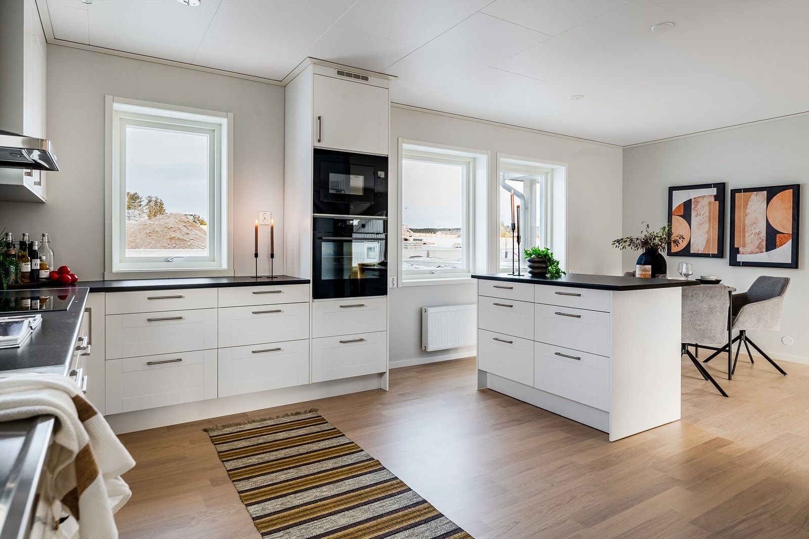 Innredningen har hvite profilerte fronter og laminert benkeplate med nedfelt oppvaskkum. Belysning under overskap. Galleribilde