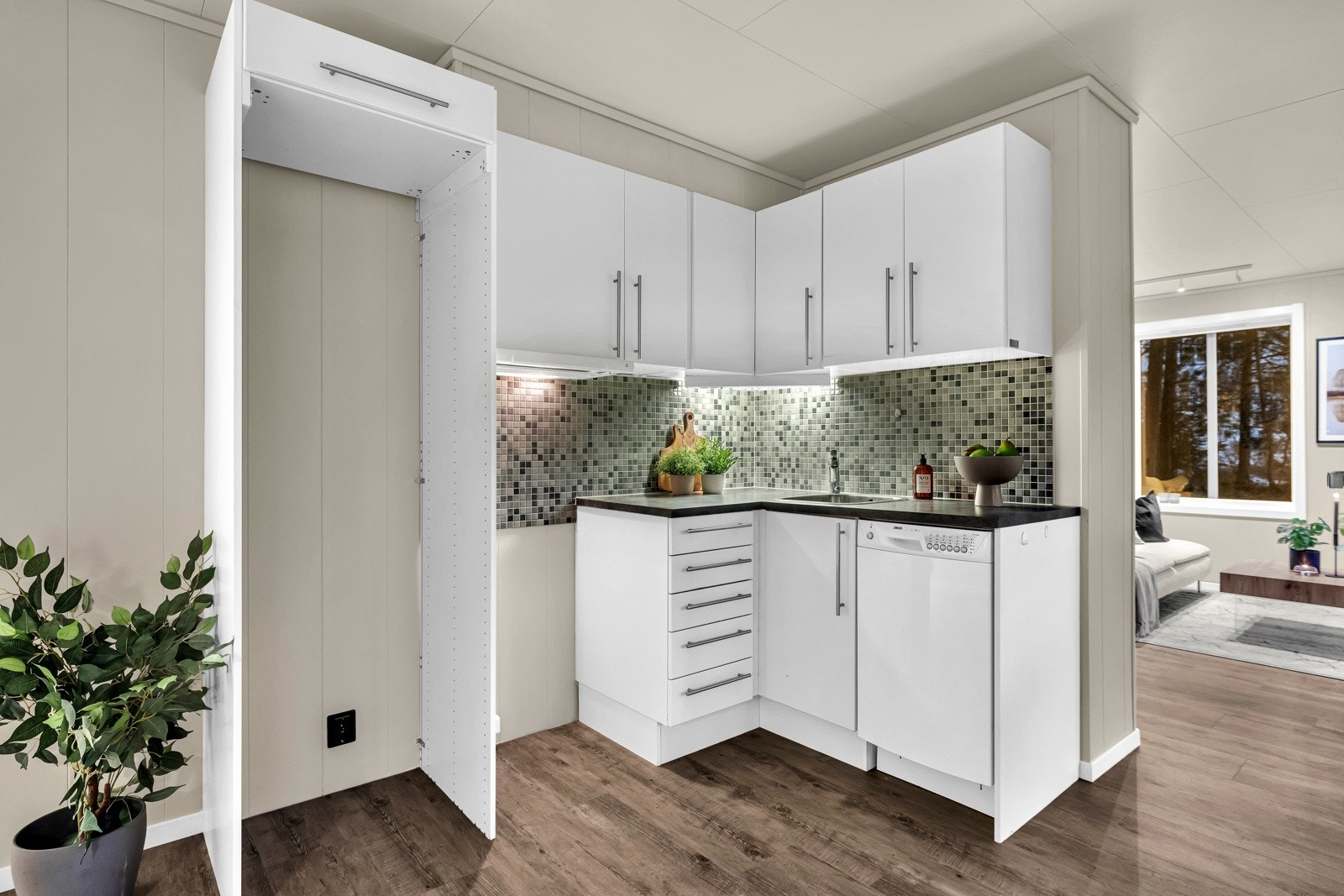 Stilrent kjøkken i åpen løsning mot stuen, fra 2007. Kjøkkeninnredning med hvite fronter og håndtak. Avsatt plass til hvitevarer. Oppvaskmaskin medfølger Galleribilde