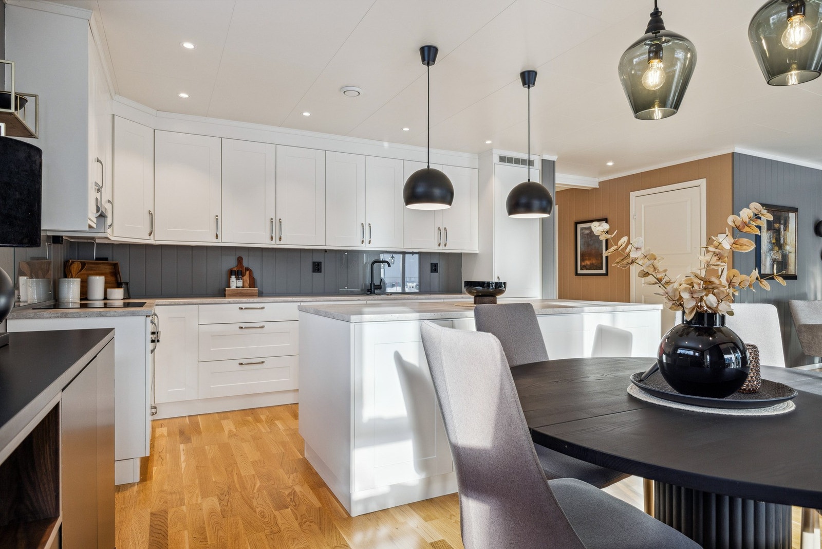 Pent og funksjonelt kjøkken med god benkeplass, integrerte hvitevarer og åpen løsning mot spiseplass og stue. Galleribilde