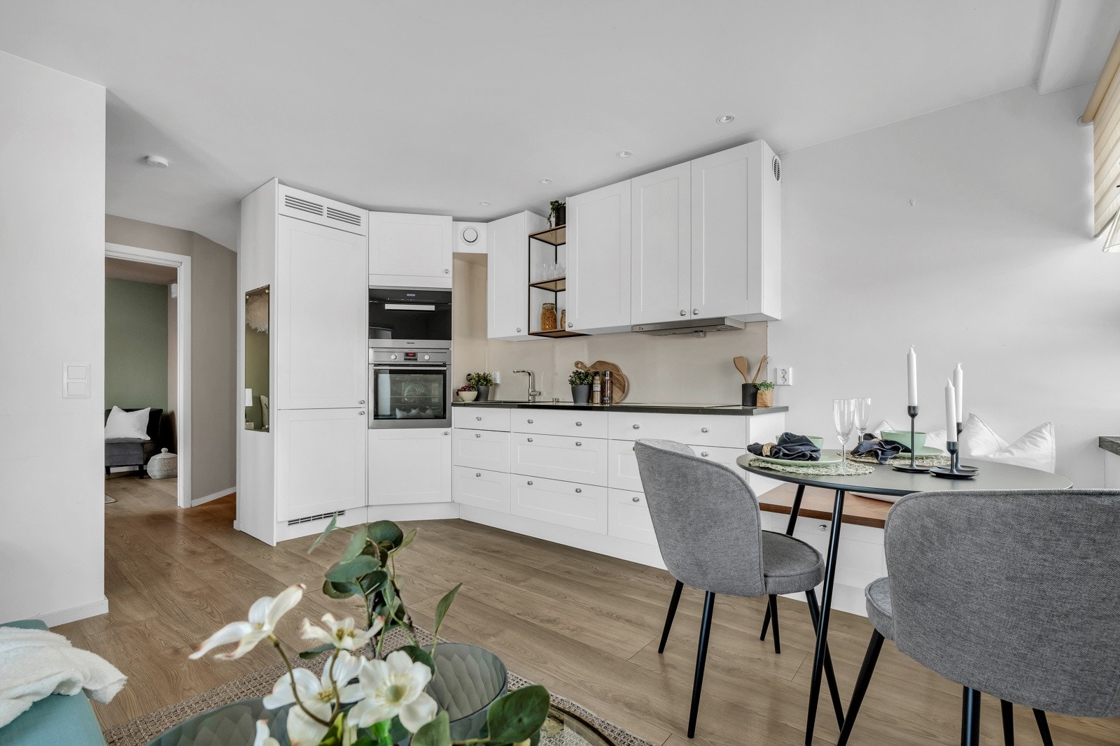 Kjøkkenet har hvite fronter, laminat benkeplate og integrerte hvitevarer. Galleribilde