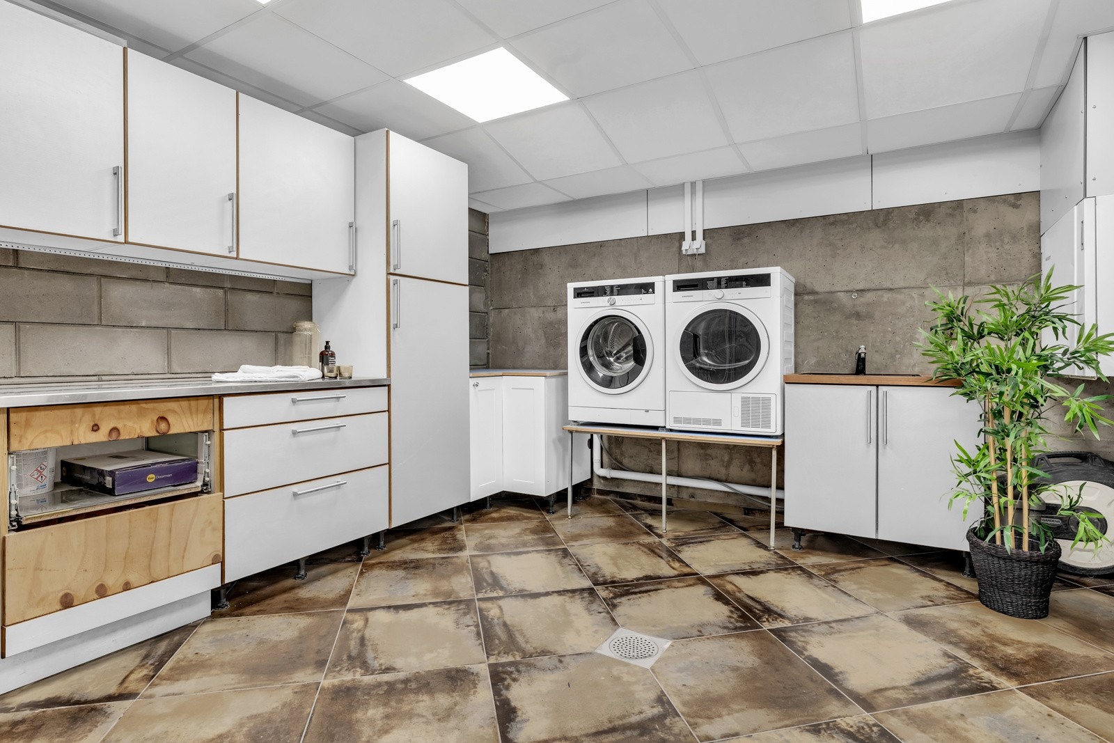 Stort og innholdsrikt vaskerom med god oppbevaringsplass og opplegg for både vaskemaskin og tørketrommel. Galleribilde