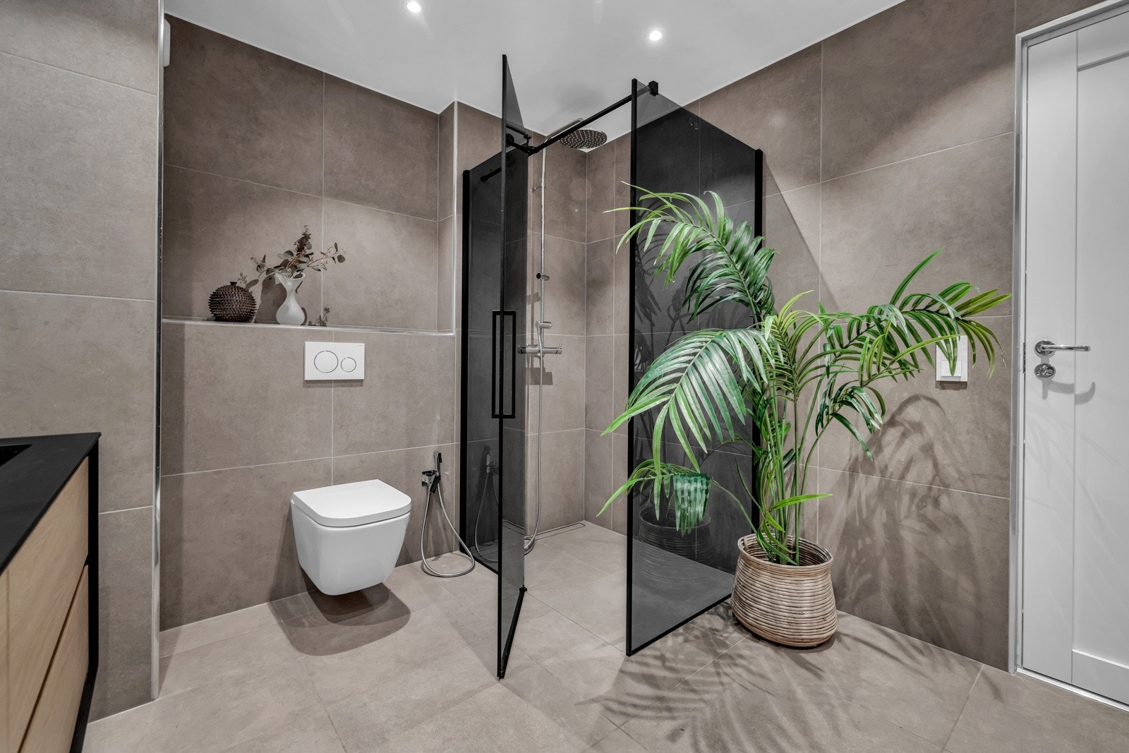 Badet har også veggmontert wc med håndspyler, og dusjhjørne med sort glassdører. Det er balansert ventilasjon. Galleribilde