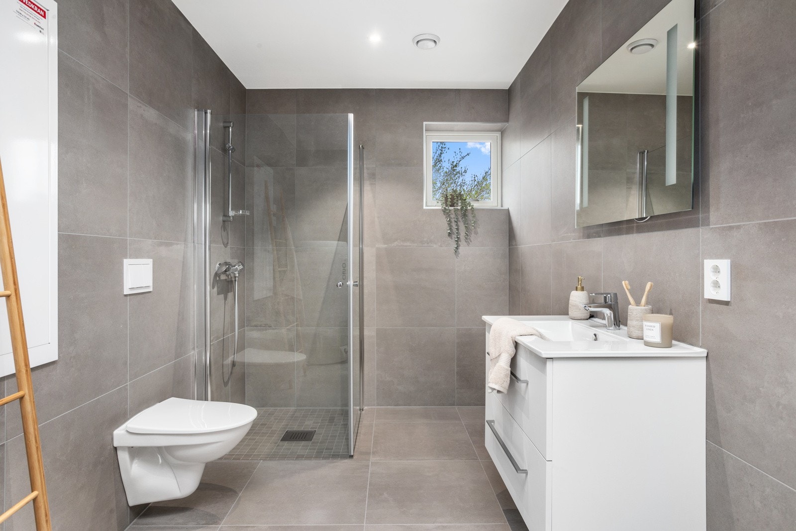 Pent, flislagt bad med vegghengt wc og dusjhjørne. Galleribilde