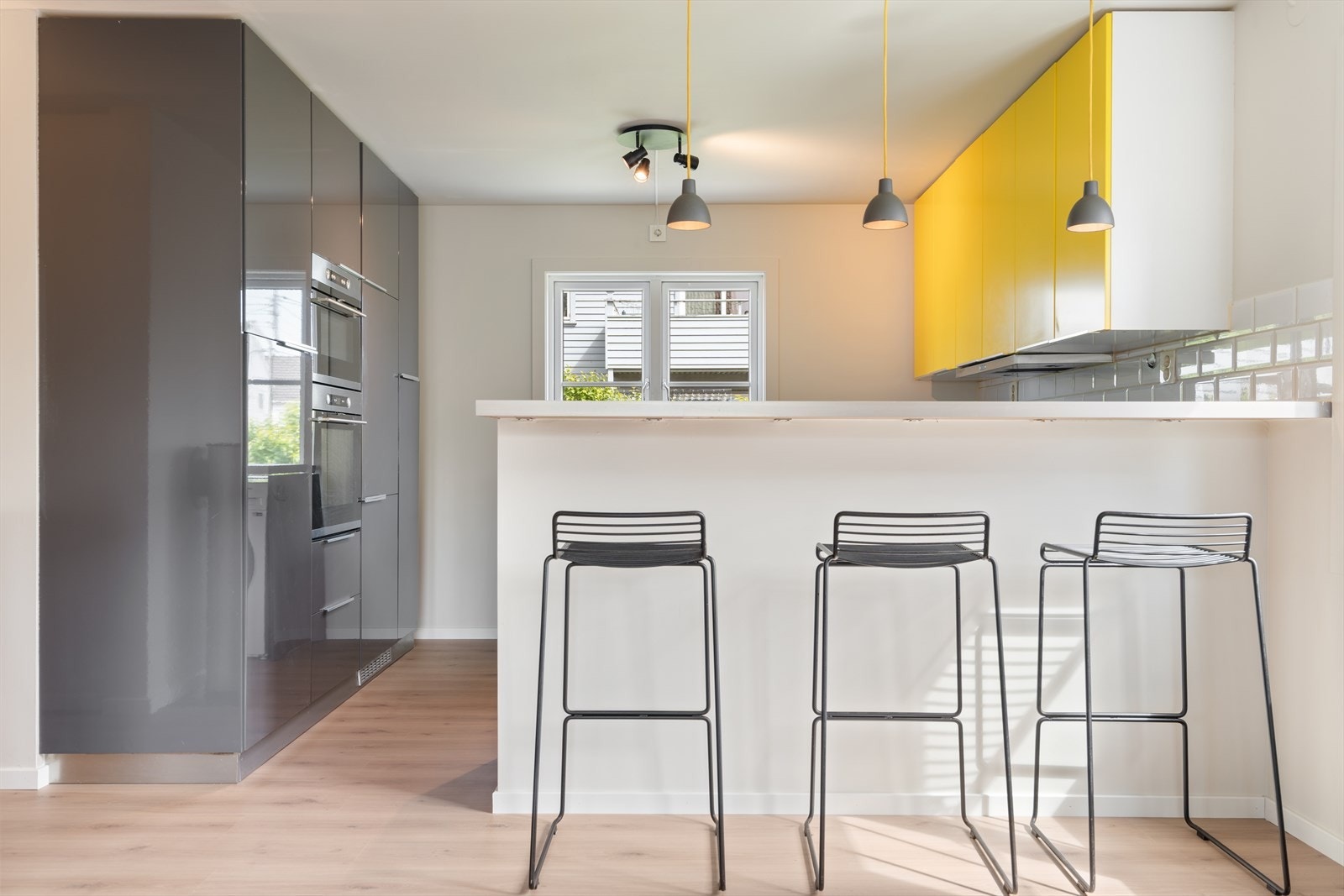 Kjøkkeninnredning med glatte fronter. Benkeplate i laminert spon. Det er integrert oppvaskmaskin, kjøl/frys, micro, platetopp og stekeovn. Galleribilde